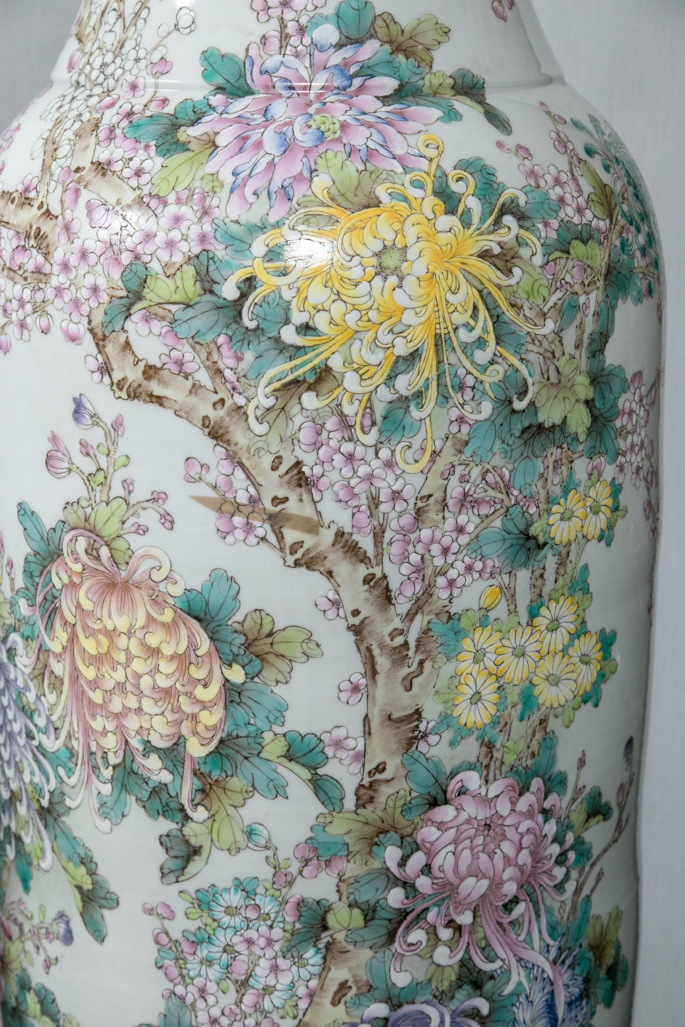 Each vase is hand-painted with prunus blossoms, mums, leaves, branches, etc. on a white porcelain ground. The rim decorated in gold.
They are 72 and 74 inches tall and approximately 20 inches in diameter.

