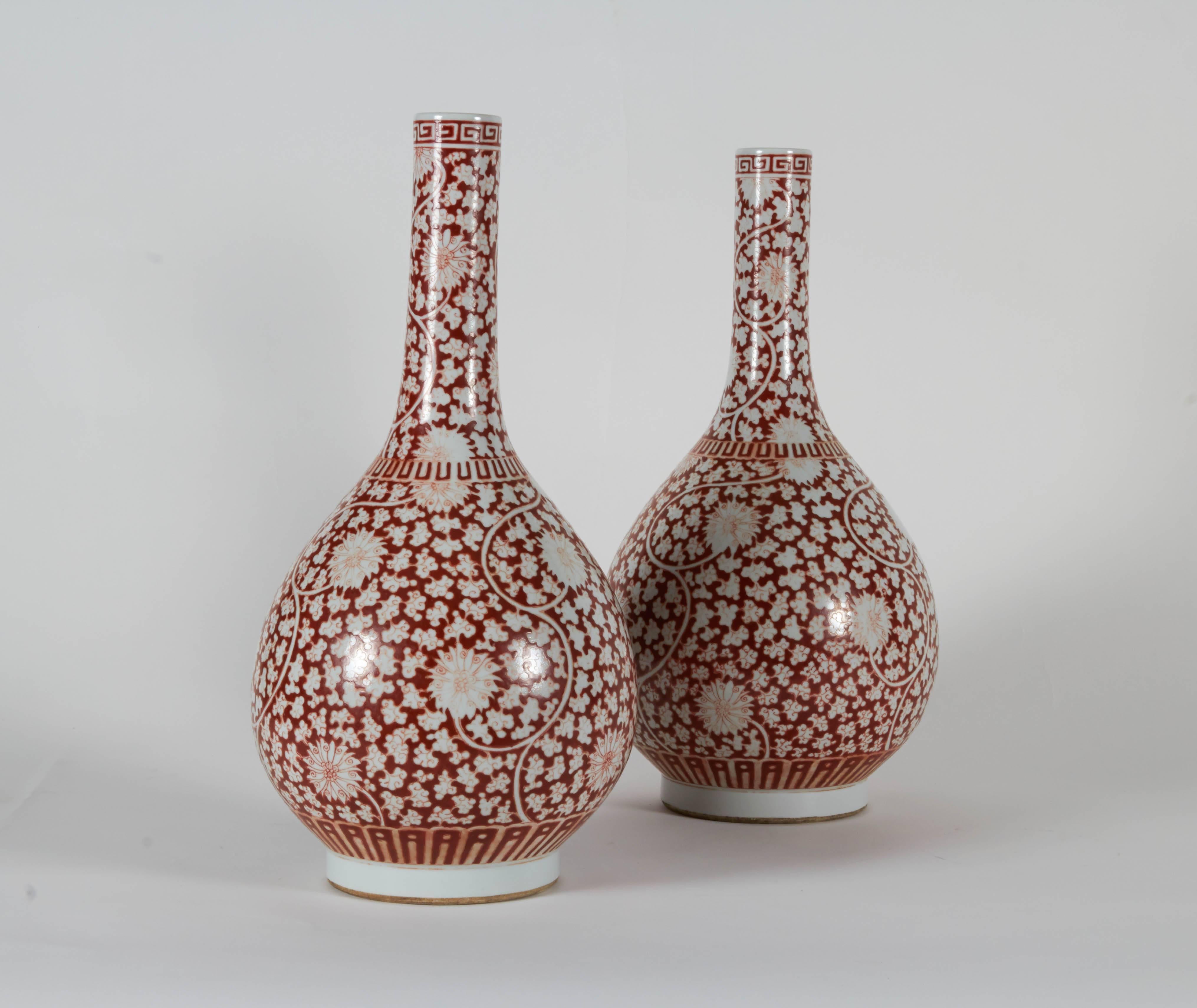 A fine pair of Chinese porcelain bottle-shaped vases, painted in the Islamic style,  Daoguang period (1821-1850).  Each vase finely handpainted in Henna colors with multi chrysanthemum flowers on a white background, further having Greek Key Scroll