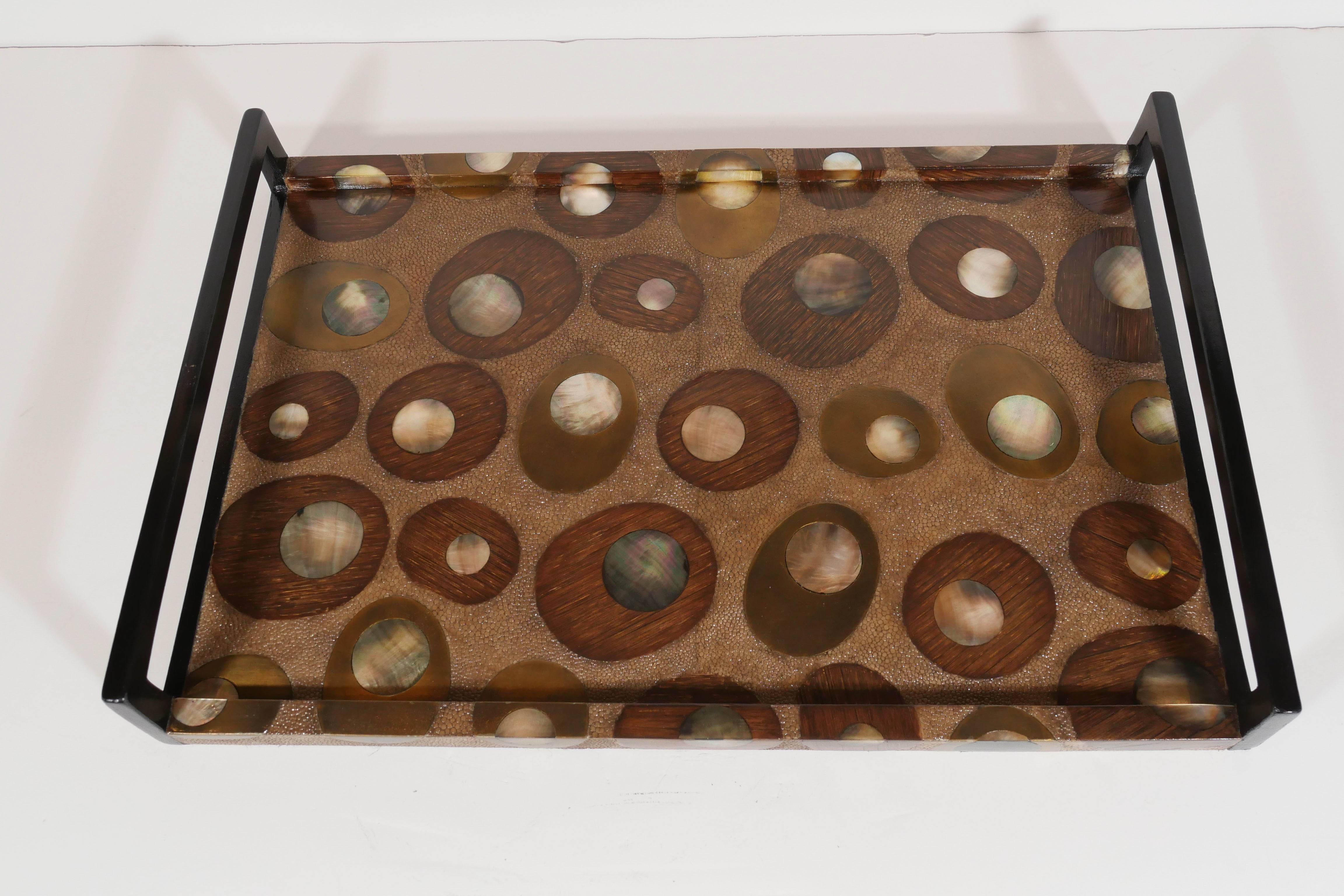 Exquisite hand crafted serving tray featuring a spectacular variety of textured materials.  Covered in exotic shagreen with hues of tan, and features mother-of-pearl inlays over palmwood insets. The combination creates a beautiful concentric and