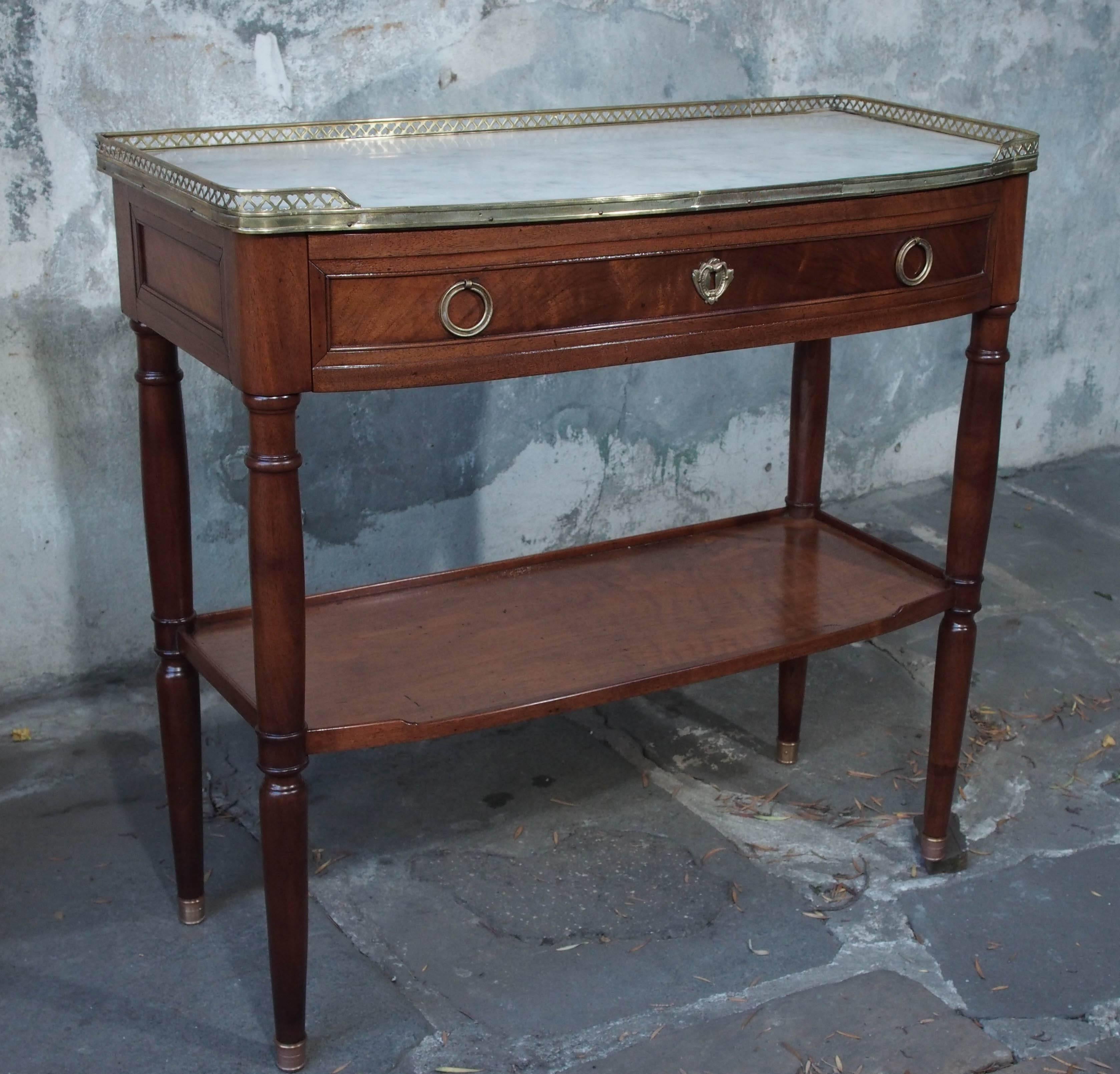 Small scale French Louis XVI period mahogany console with shelf, drawer and white marble top with brass gallery