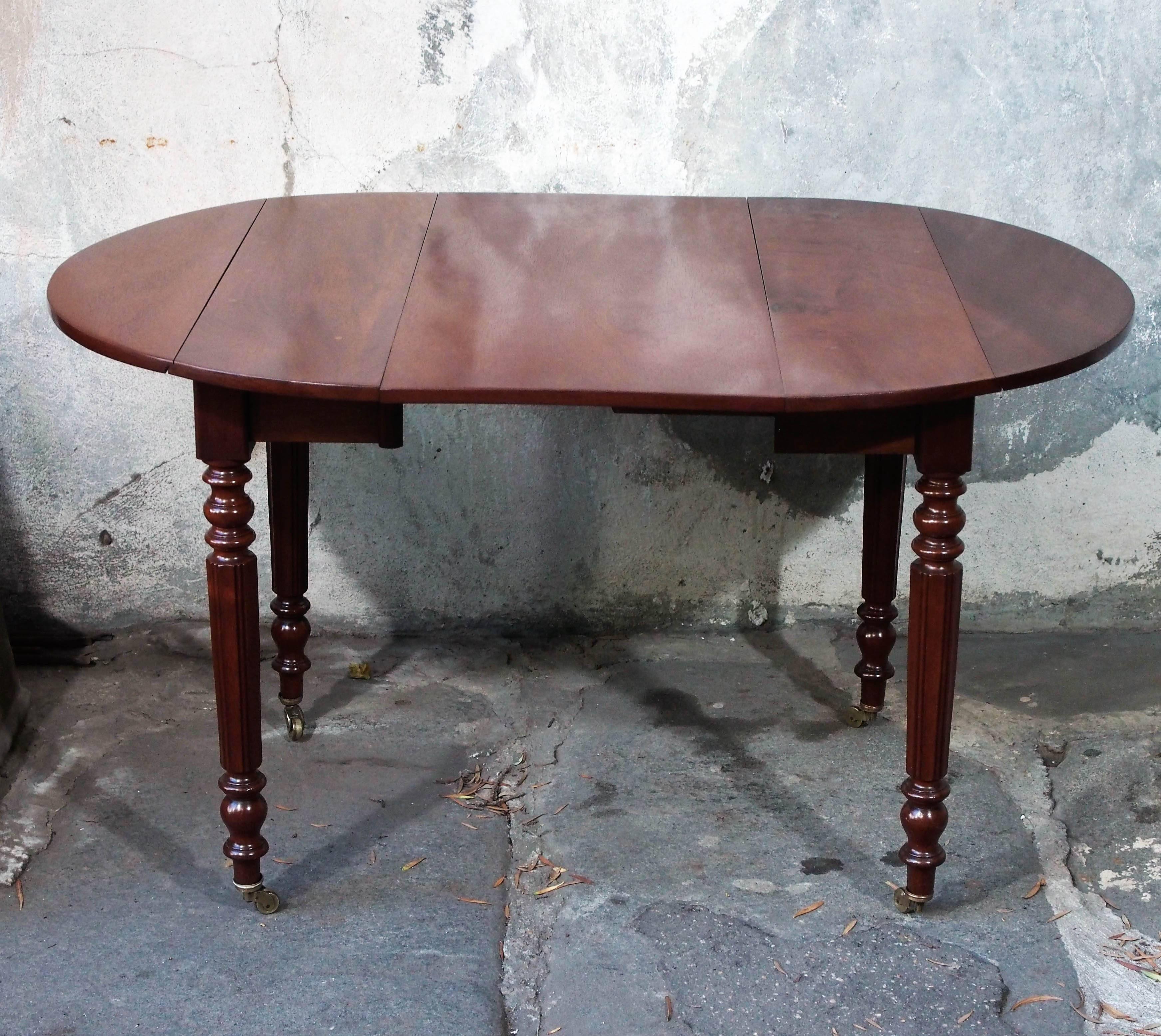 Charming early 19th century French walnut child's drop-leaf dining table with turned and fluted legs, with runner system and one additional leaf to expand size.