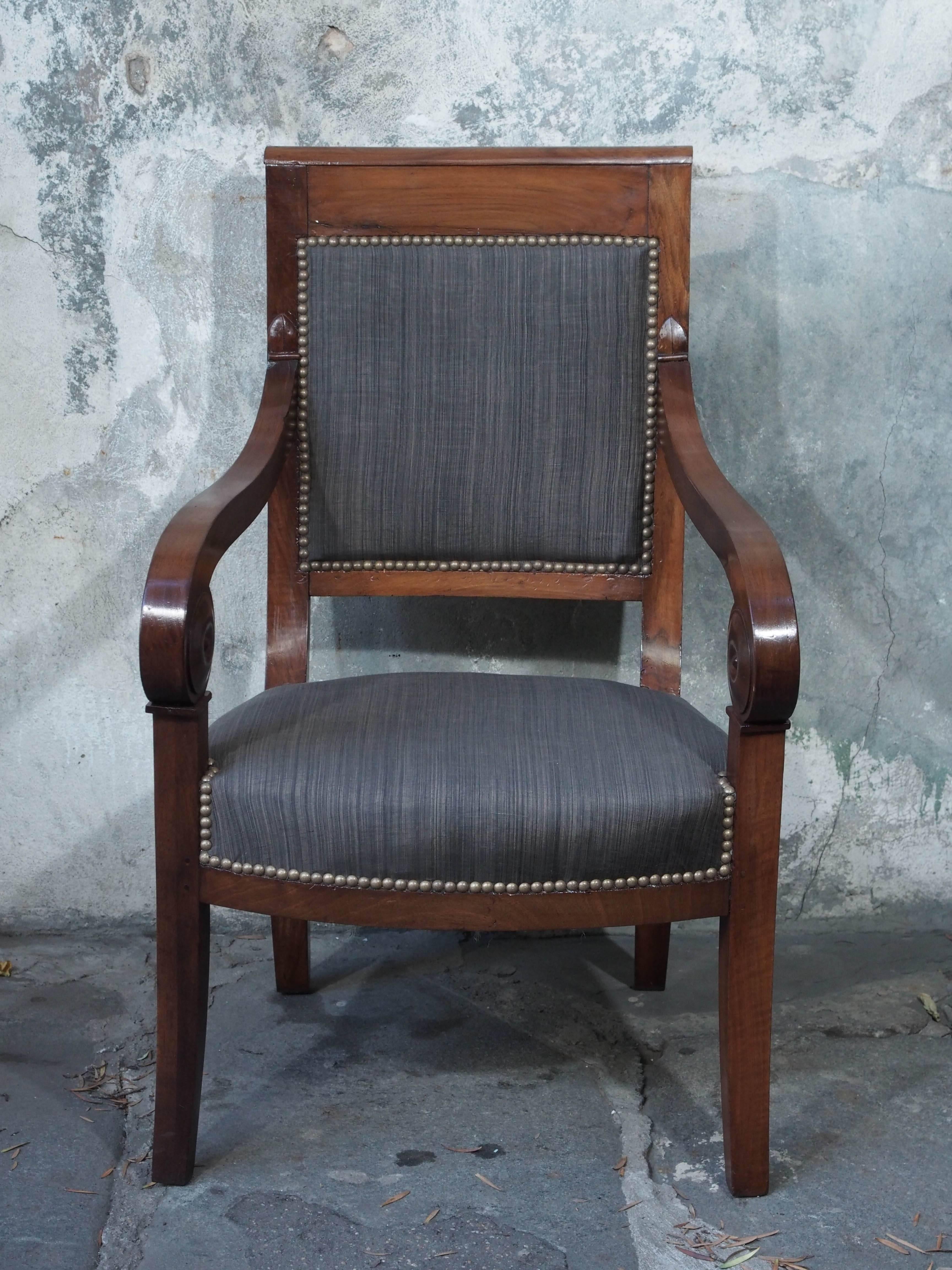 Pair of French Restauration period walnut fauteuils with scroll arms and fresh upholstery