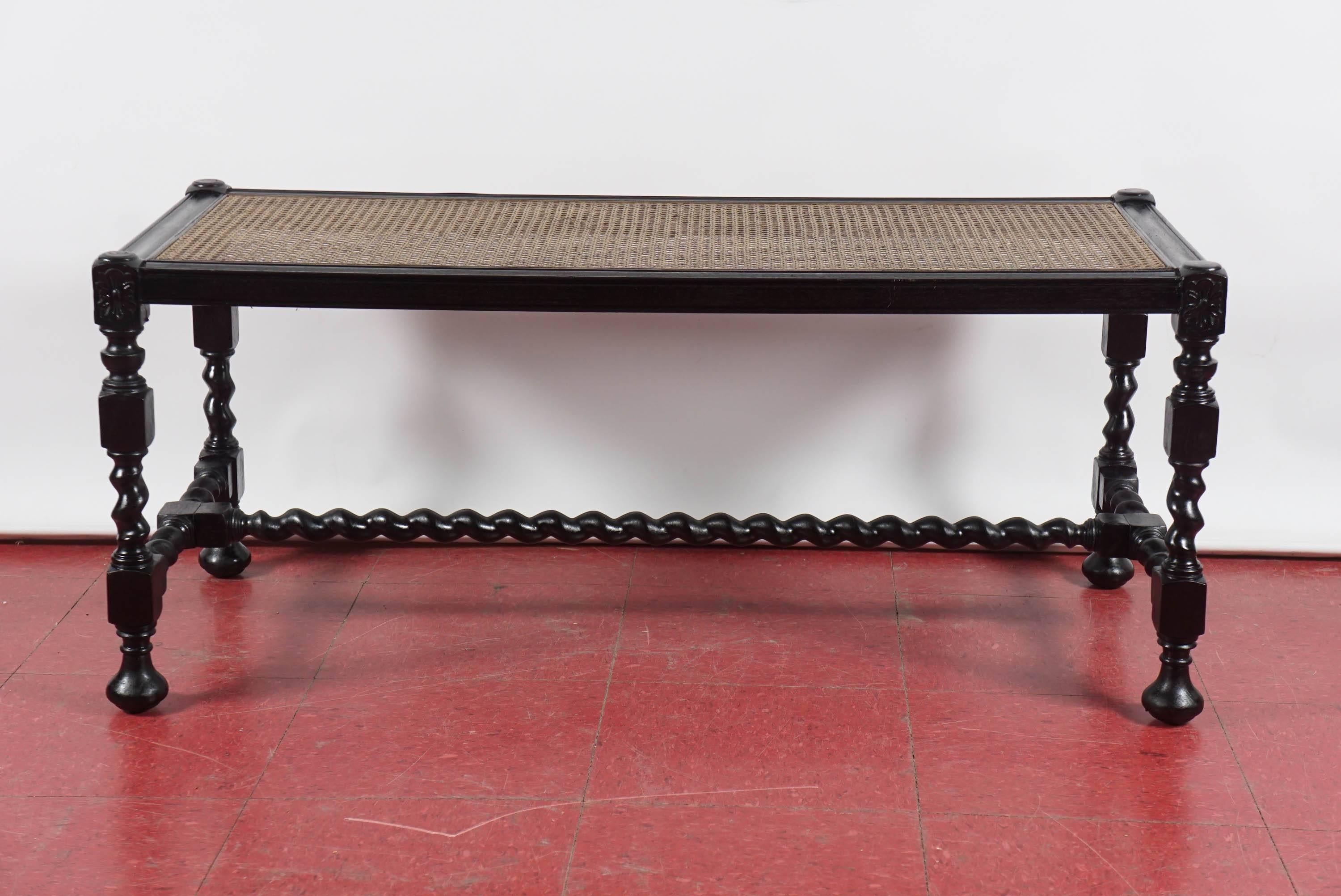 This antique English Jacobean style bench with turned legs, barley twist stretchers and has a new cane seat. Perfect for adding a cushion to be used as extra seating, at the foot of a bed or in front of a fireplace.