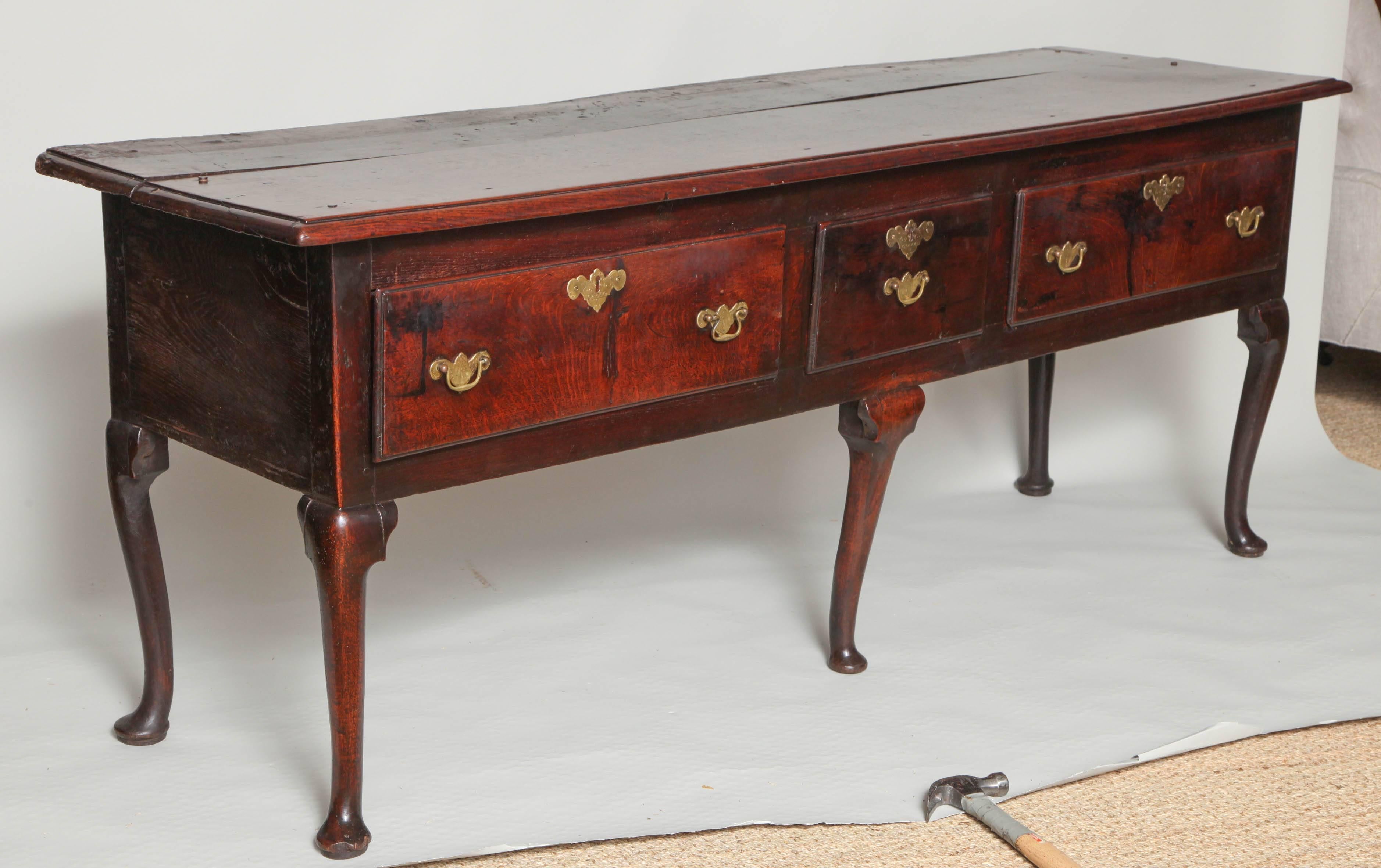A very good mid-18th century English oak low dresser having a generously overhung top with thumb molding over three drawers and standing on well formed cabriole legs, the whole with rich, lustrous surface, West Country - possibly Somerset or Dorset,