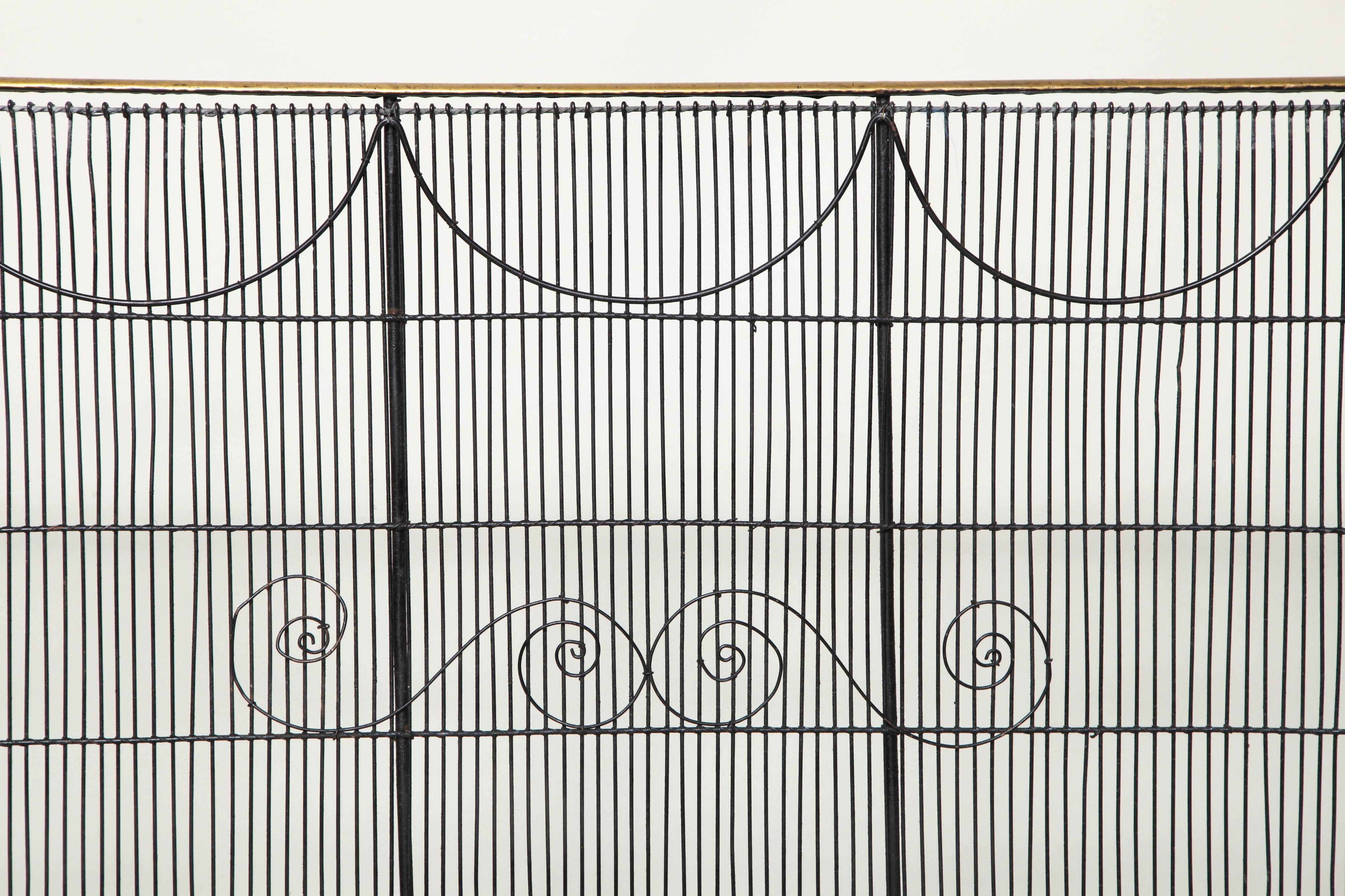 Very fine and unusually sized English Mid-19th Century nursery guard, the iron frame with vertical iron wire stringing decorated with swags and scrolls, the top rail in polished brass, England, circa 1860.