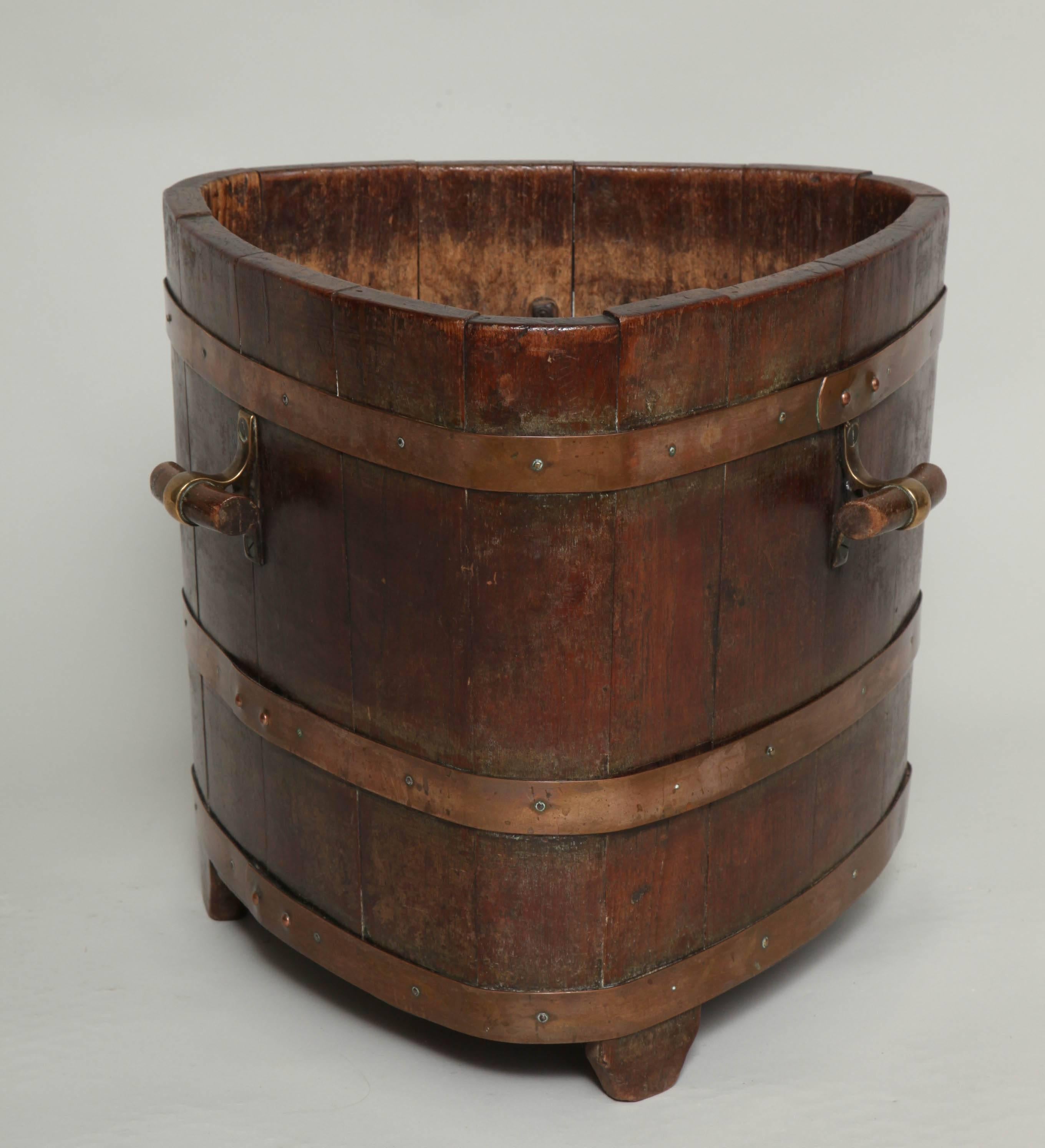 Most unusual late 19th century oak triangular barrel form log bin with three toggle handles and three bronze bands, the whole with good rich color.