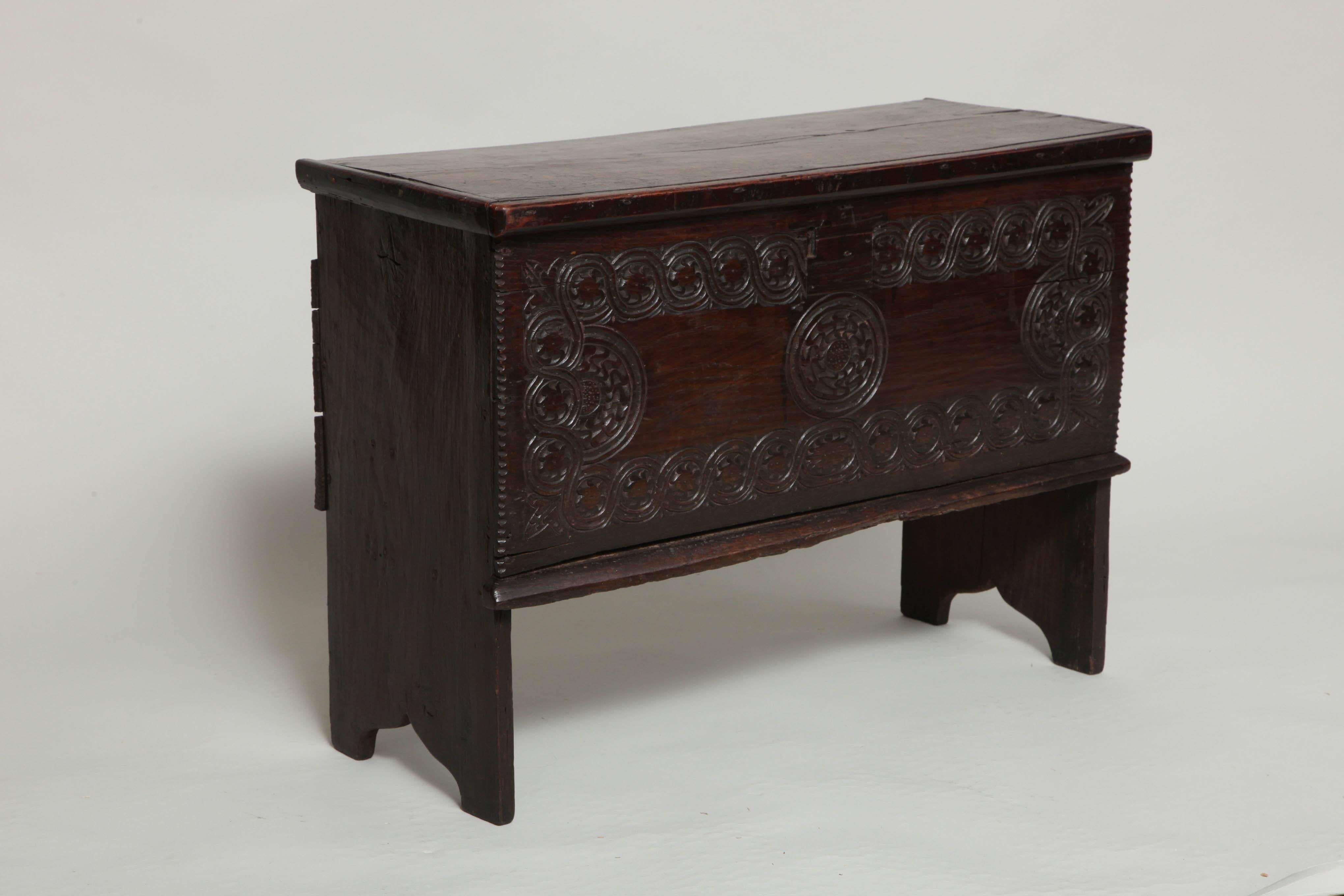 Fine mid-17th century diminutive six plank coffer having a single plank top with molded edge, standing on boot jack feet, the front with fine geometric chip carving, the whole with good, rich color.  Useful scale.  English, circa 1650.