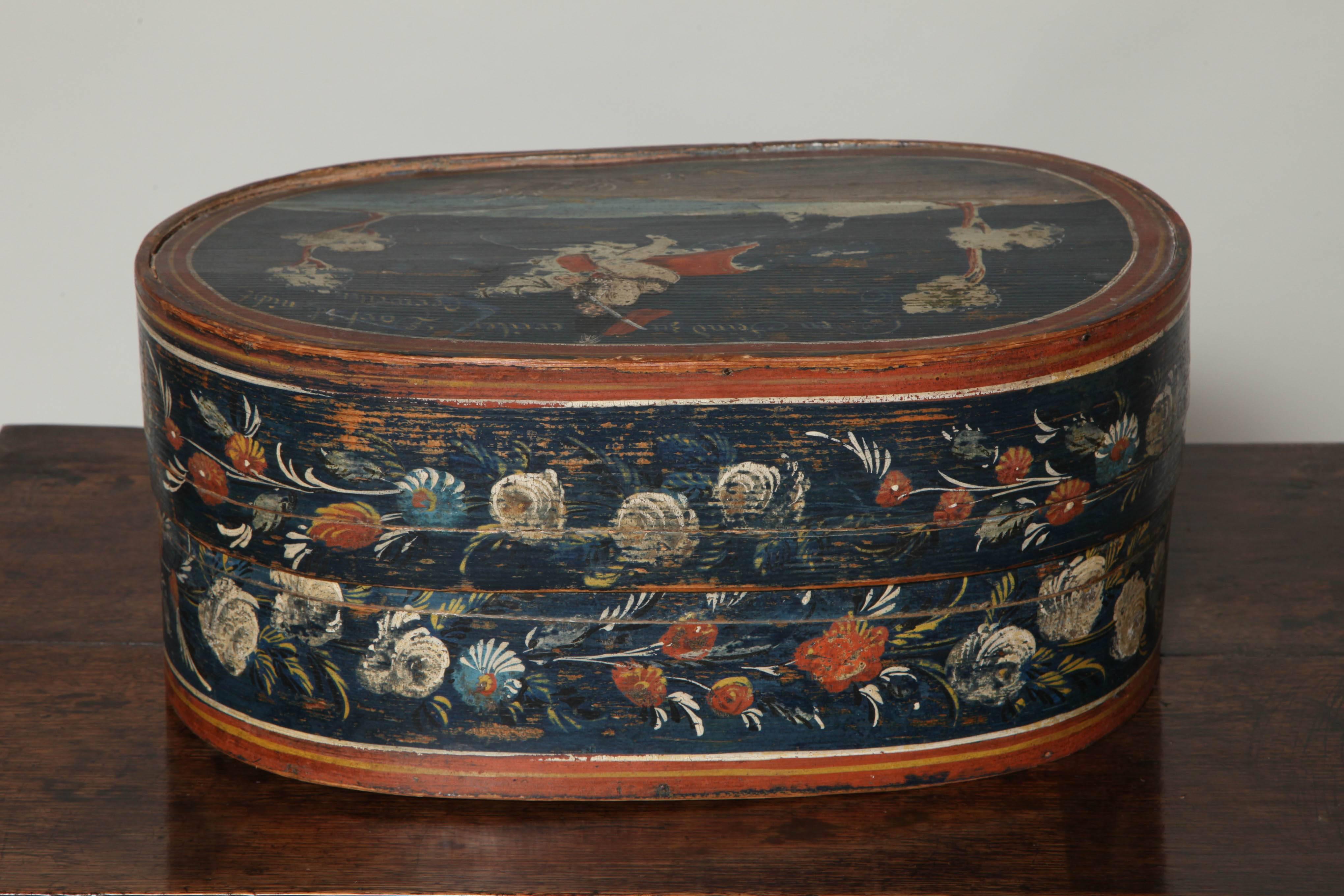 Very fine early 19th century Scandinavian pantry box, the oval body elaborately decorated with rosemaling, the lid with painted cavalry officer on horseback, the whole with original surface.