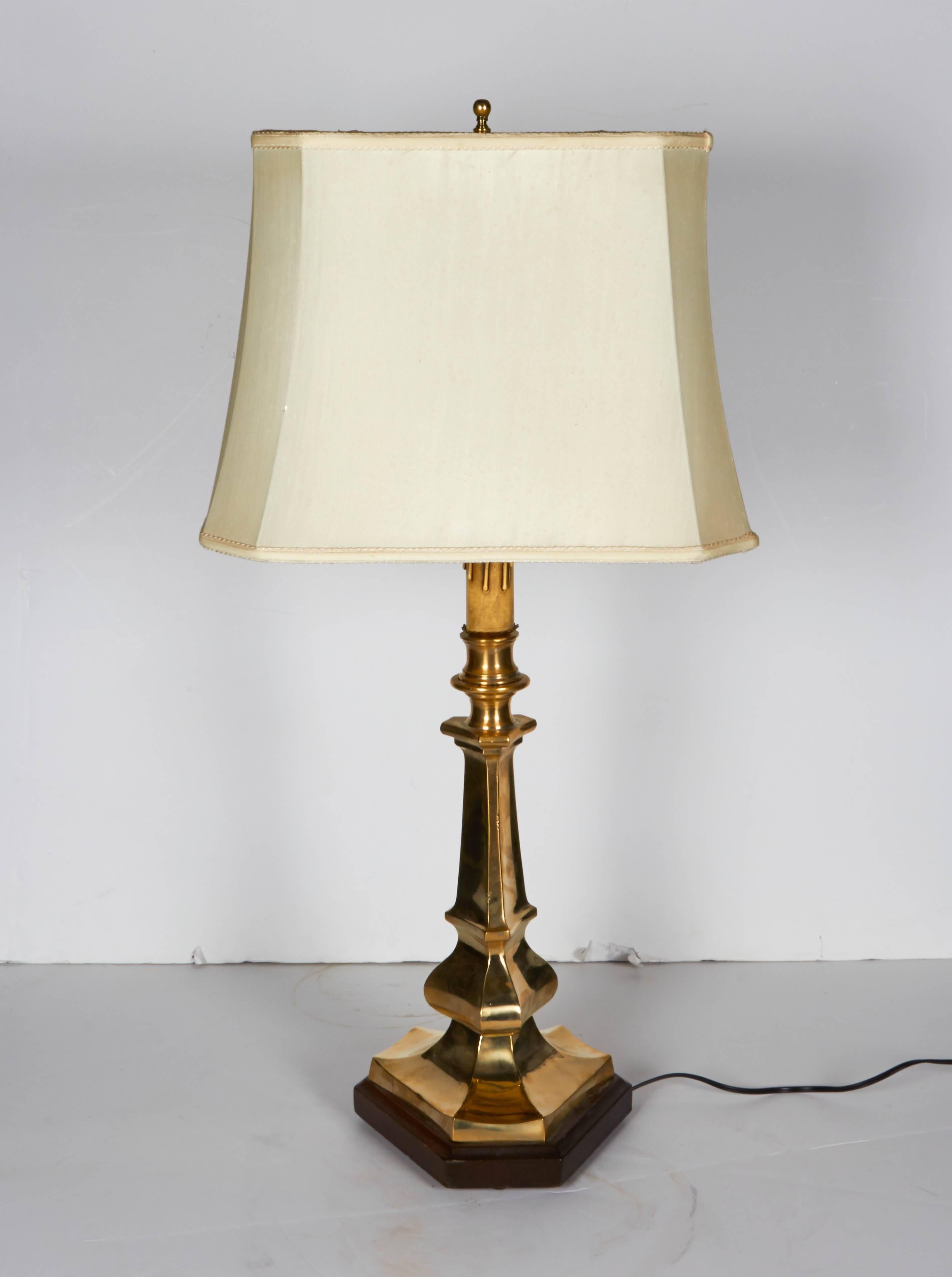 Classical Regency style Italian candlestick table lamp. Cast in solid brass with a triangular design and resting on a wood base. Nice heavy weight. Measures: Base is 9.5
