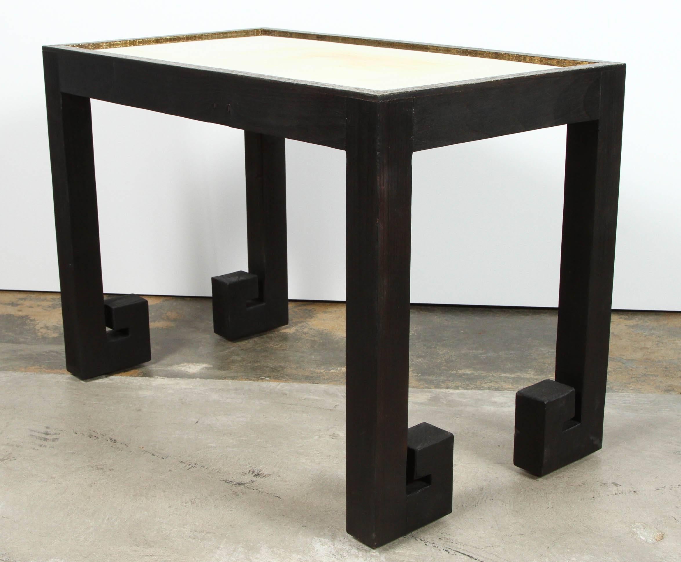 Modern pair of  Greek Key tables in distressed wood with black finish and top edges in mottled gold. Unlacquered brass inset.  Organic modern. Price is for in-stock pair. 

See last two photos as example for brass sheen - reflective quality. As