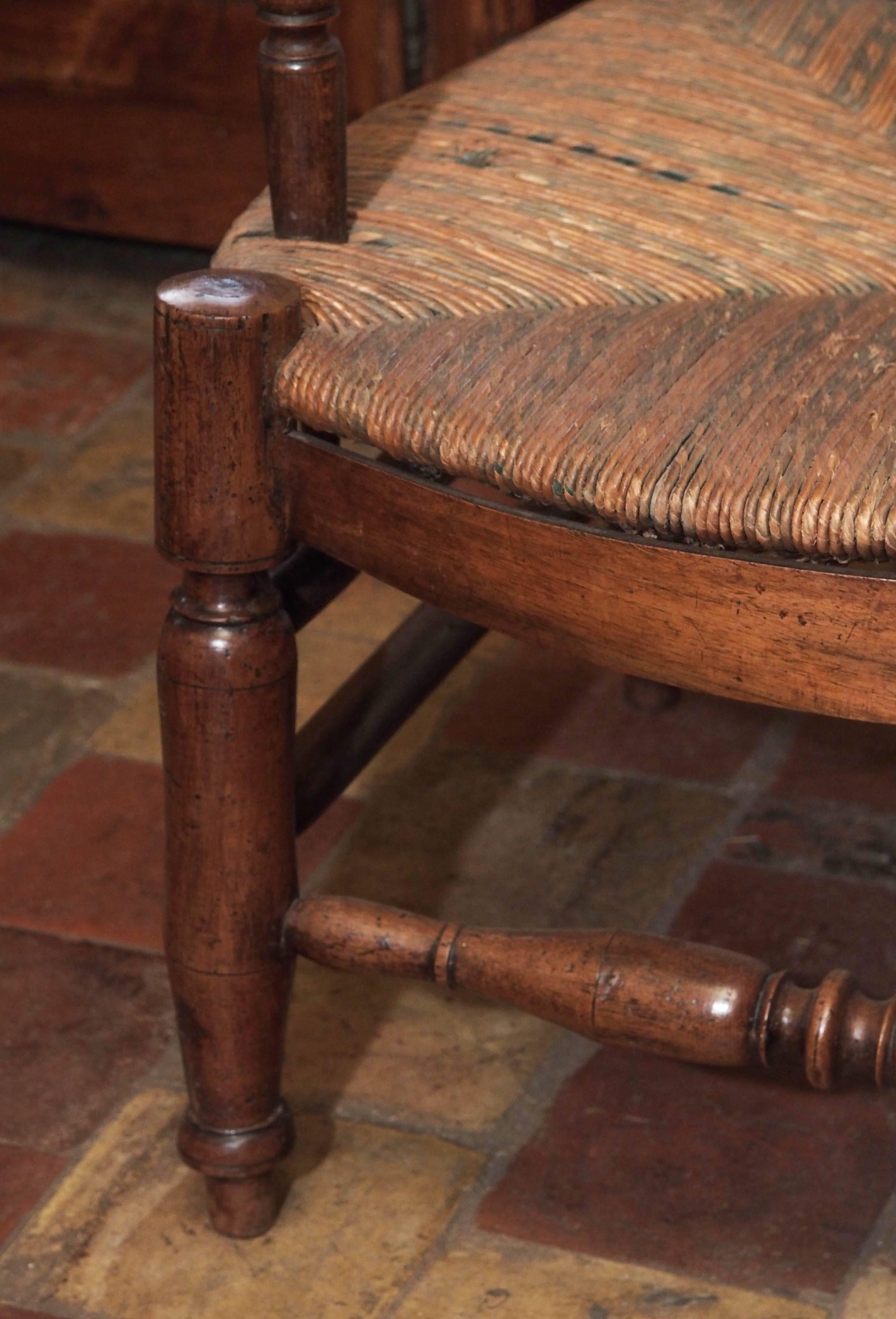 18th century Directoire hand-carved French walnut Provençale rush three-seat radassier. This was purchased from a Provence Mas from the decedents of the original family. The multicolored rush is in very good condition. It's patina is a luscious warm