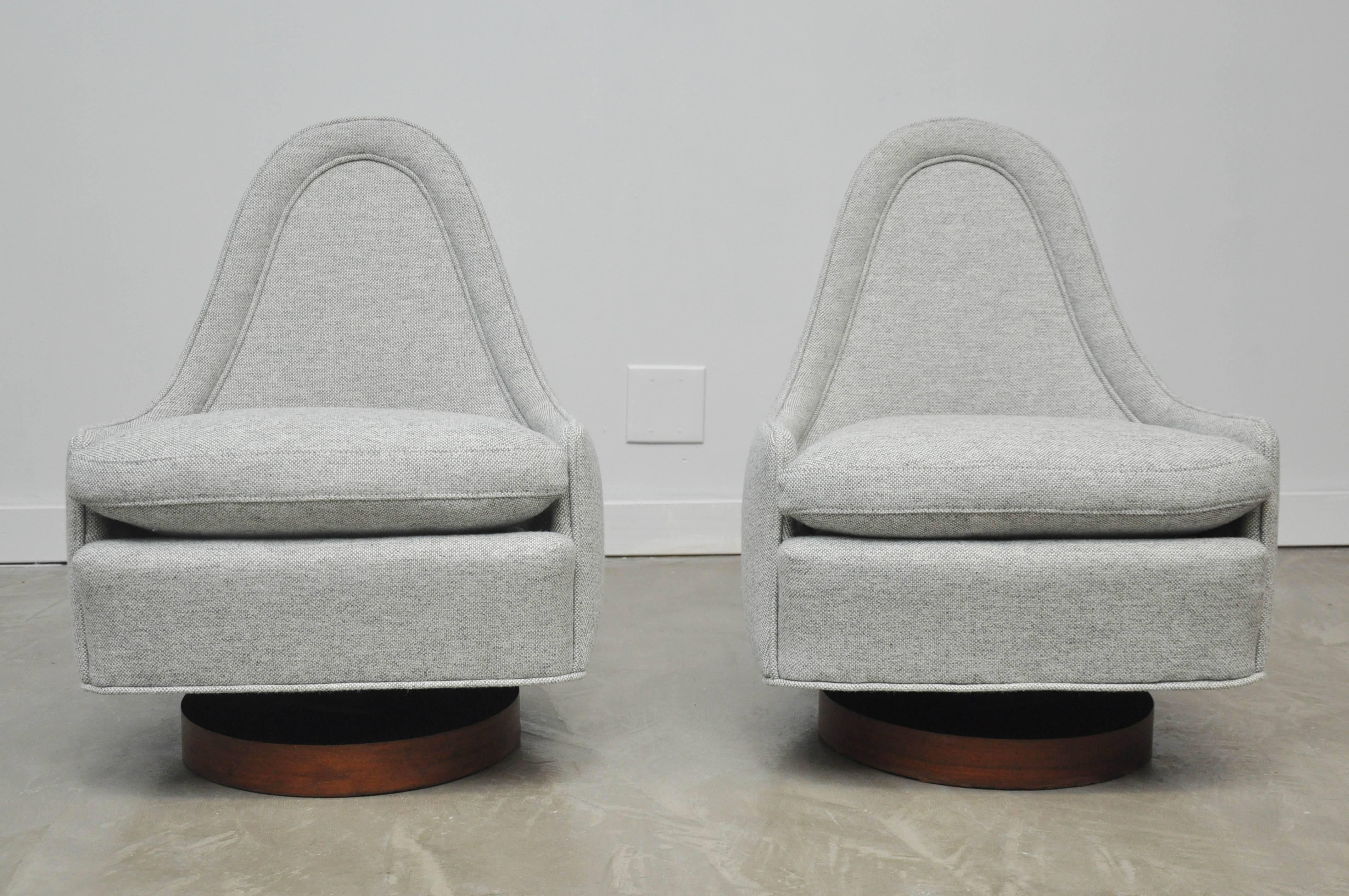 Teardrop shape lounge chairs by Milo Baughman.  Unique petite form perfectly fits body form.  Chairs swivel and tilt.  Newer grey tweed fabric over original walnut bases.