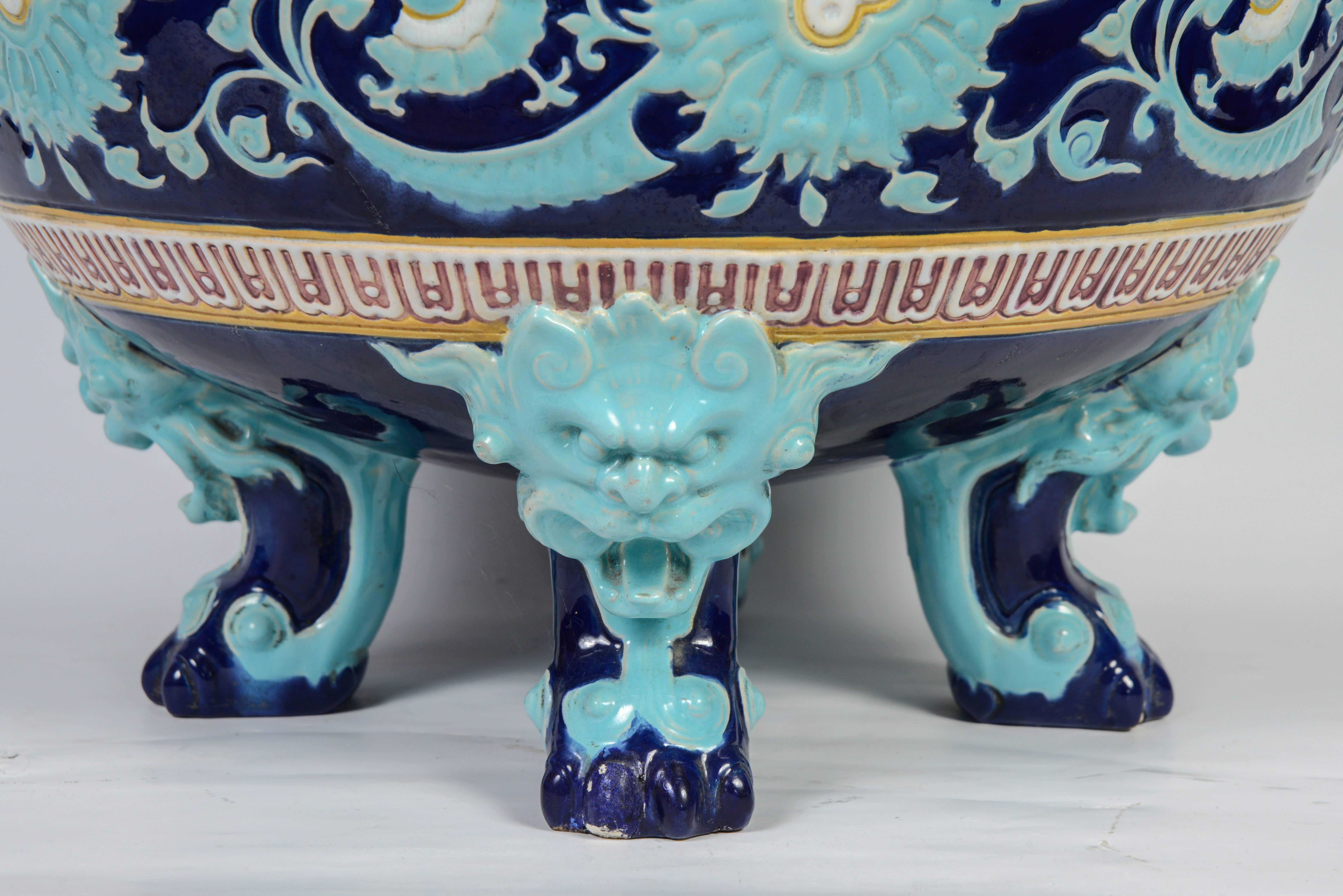 Japanese style planter in ceramic with glaze cover from the Minton English Factory made in 1893 for the Universal Exhibition of Chicago.
The body rests on three zoomorphic feet with dark turquoise blue and blue hybrid figures evoking creatures from