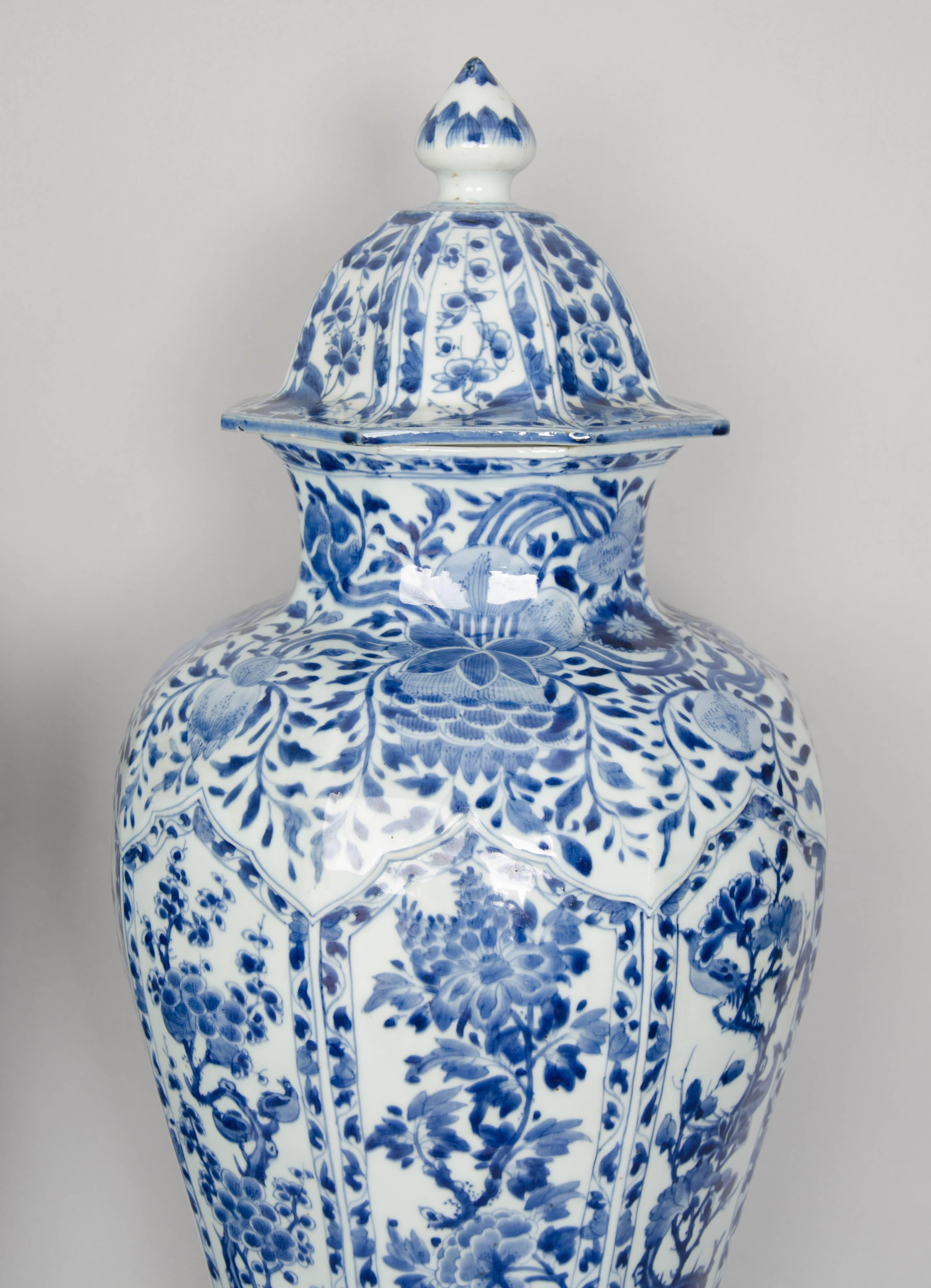 
A very large pair of Kangxi Blue and White porcelain vases and cover circa 1690-1700. The moulded porcelain vase faceted sides with unusual moulding above the flared base. Painted in rich tones of cobalt blue with panels of flowers, these include