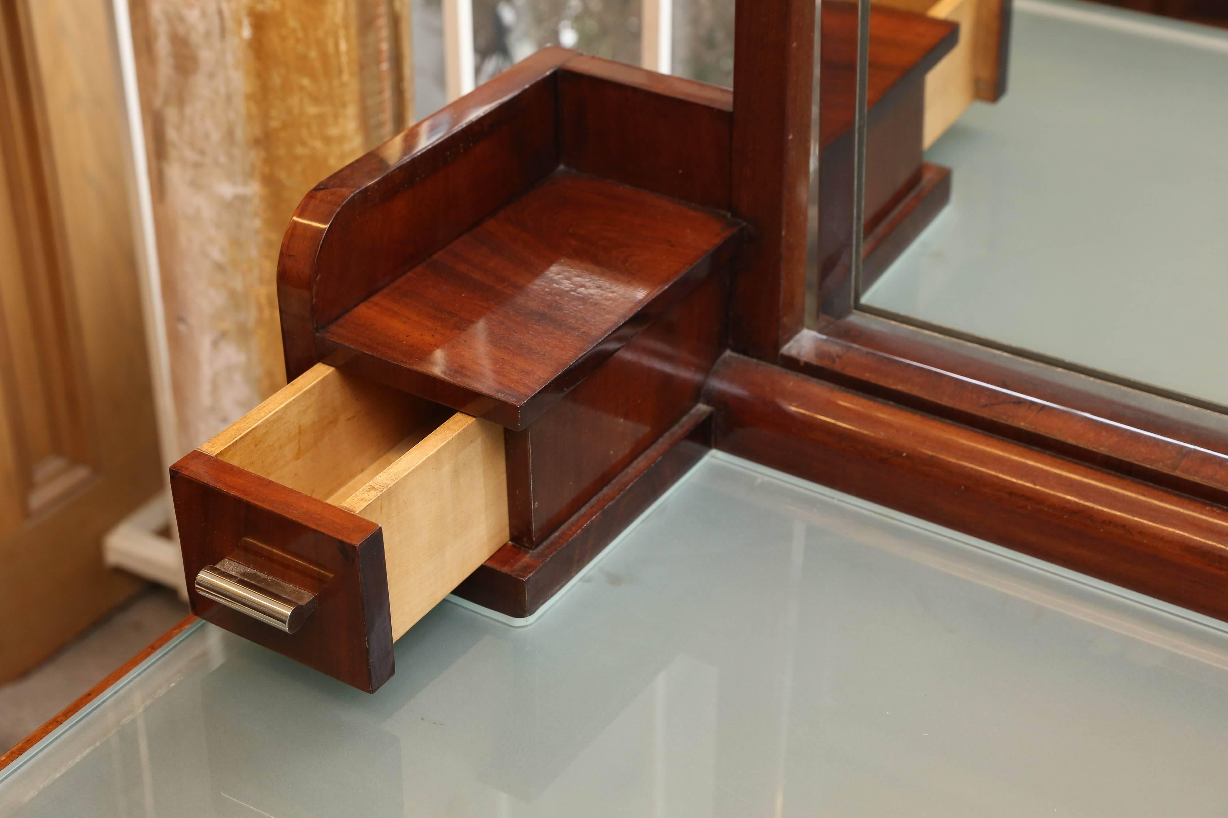 Great walnut, with thick milk glass top. Having a mirror with light above it, and placed between an elevated shelve, drawers on either end. Resting on side supports with a cabinet on the right. Nicely featured with chromed accents. Resting on six