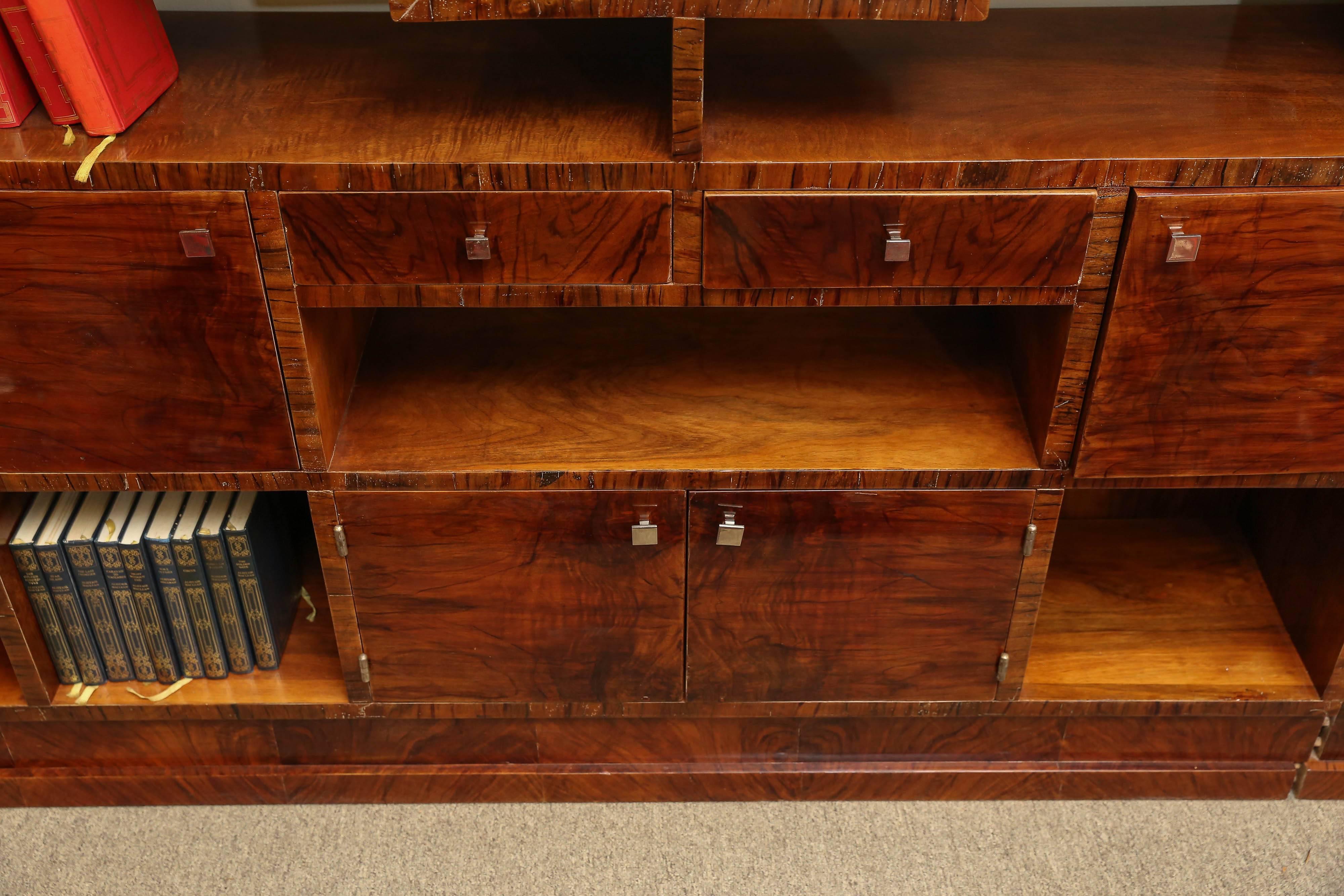 This functional Art Deco bookcase could also be used as a display case, and room divider. Fine walnut veneer in selected patterns covers this fine furniture piece. Both sides are finished and French polish applied. Having four door covered