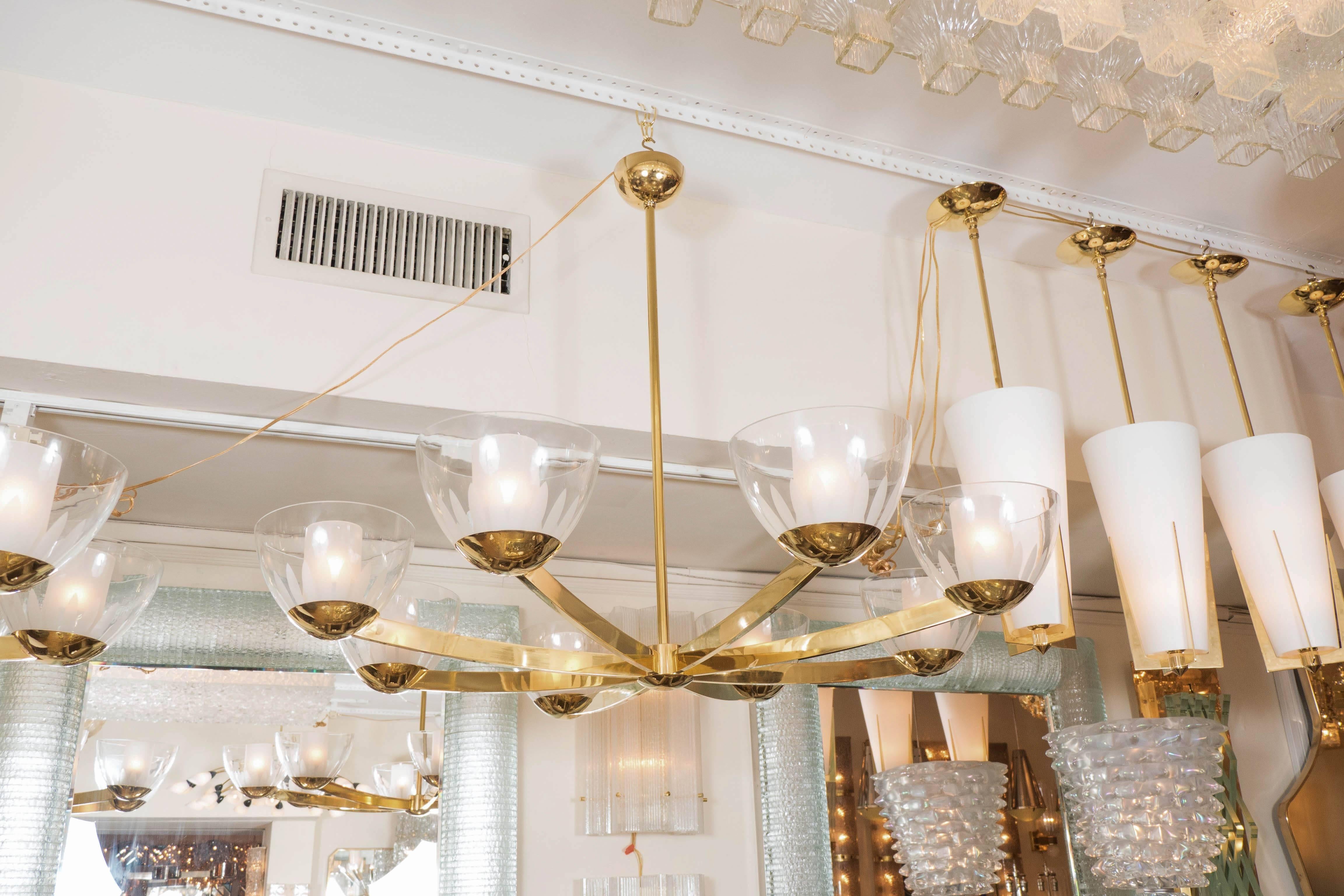 Eight-arm brass chandelier featuring clear glass bobeches with frosted floral design.