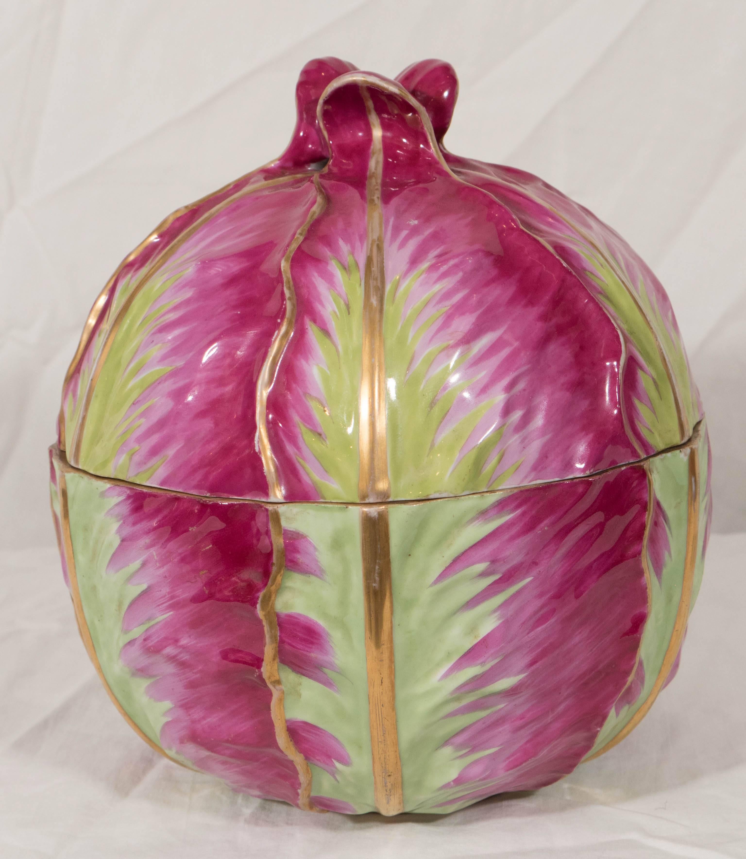 A Meissen tureen and stand modeled as a cabbage sitting on cabbage leaves decorated with an imaginative color combination of bright fuchsia and green.