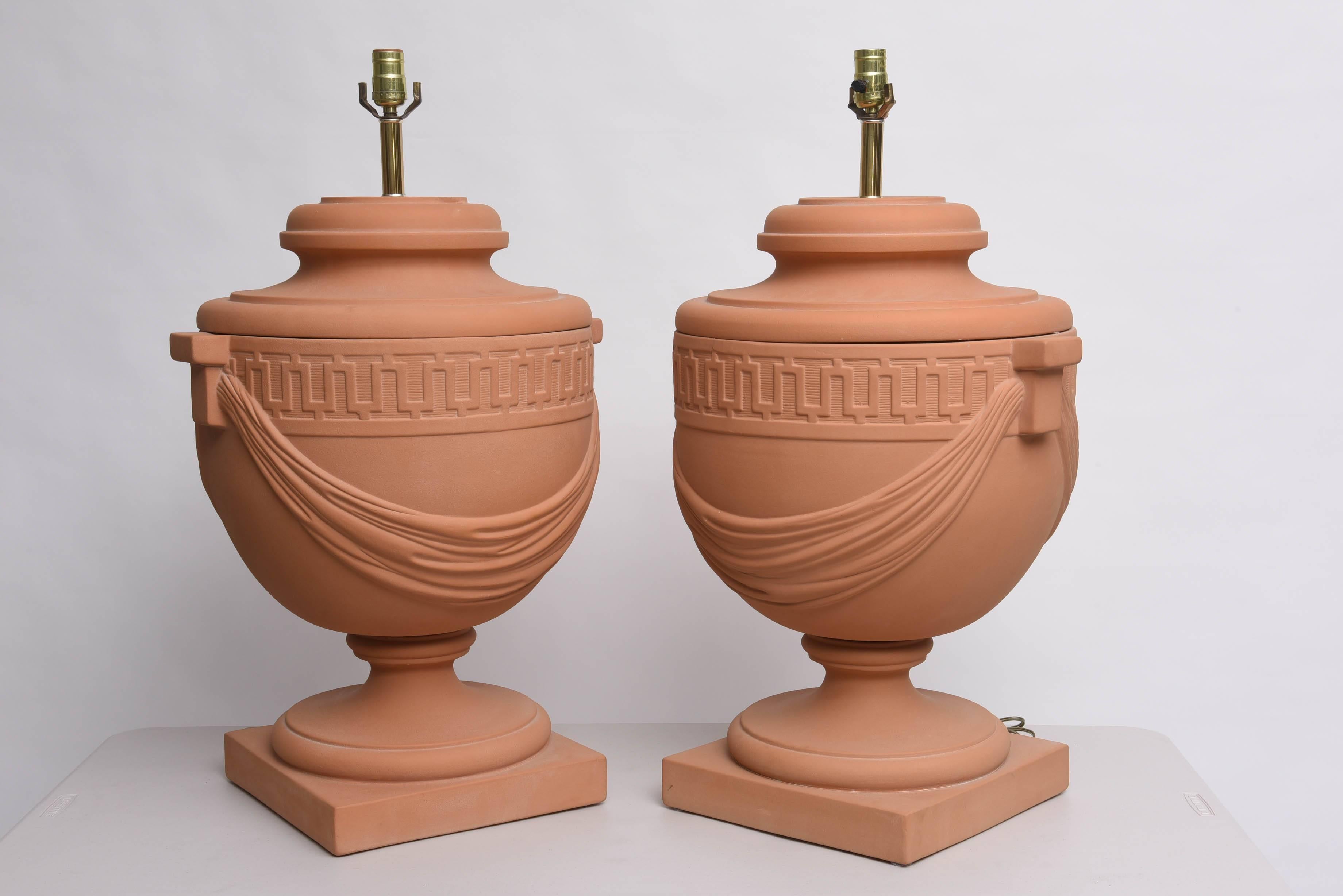 This amazing monumental scaled table lamps are cast plaster with a terra-cotta coloration.  They have the classic stylized Greek-Key border and swaged fabric that give them a great presence.

Note:  Pieces retain their original wiring.

Please