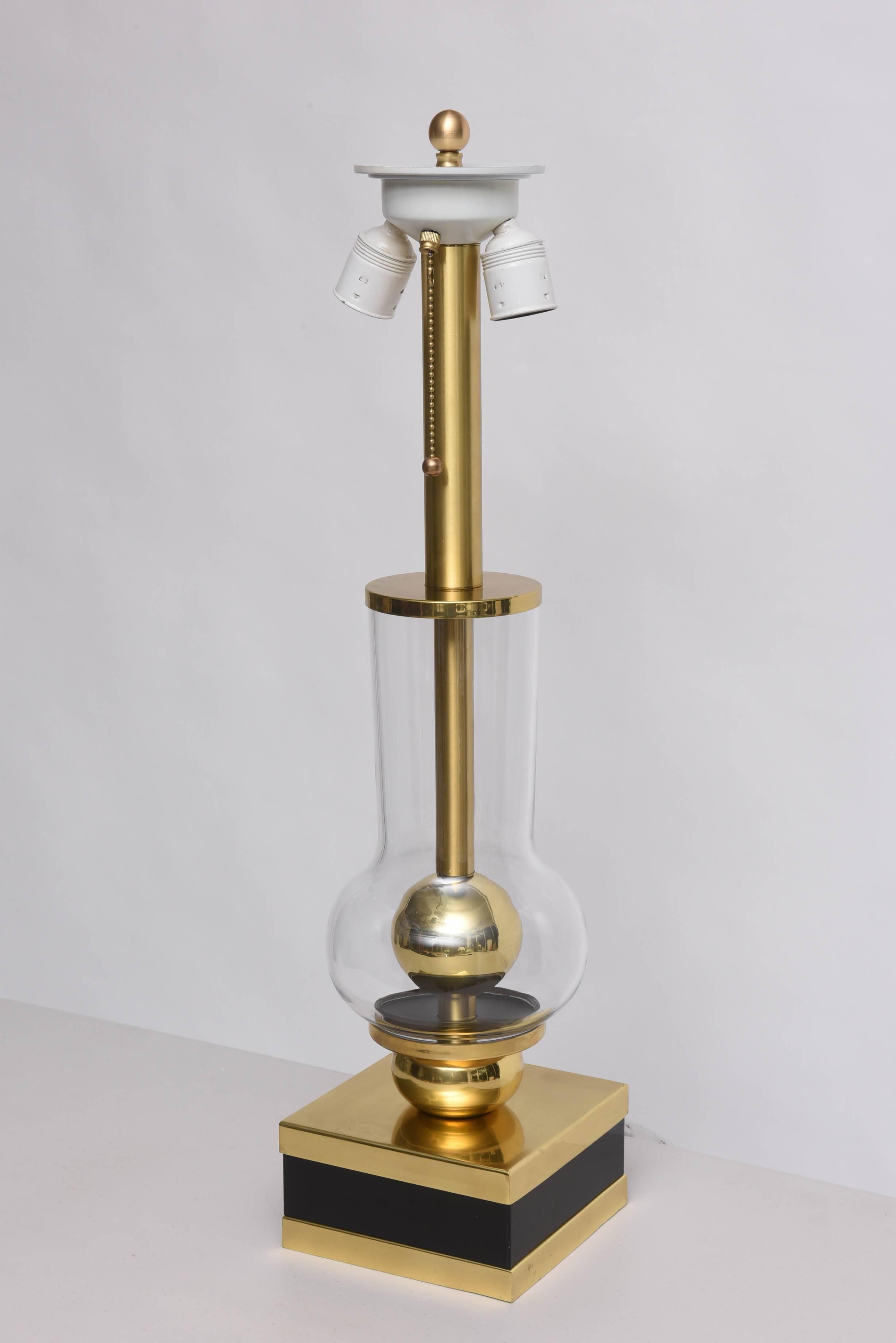 This amazing table lamp is attributed to Studio Willy Rizzo and was created in the 1960s-1970s. The piece is in polished brass with a painted black-band on the base and the clear glass globe encasing a sphere of brass.

Note: The base is 6.50