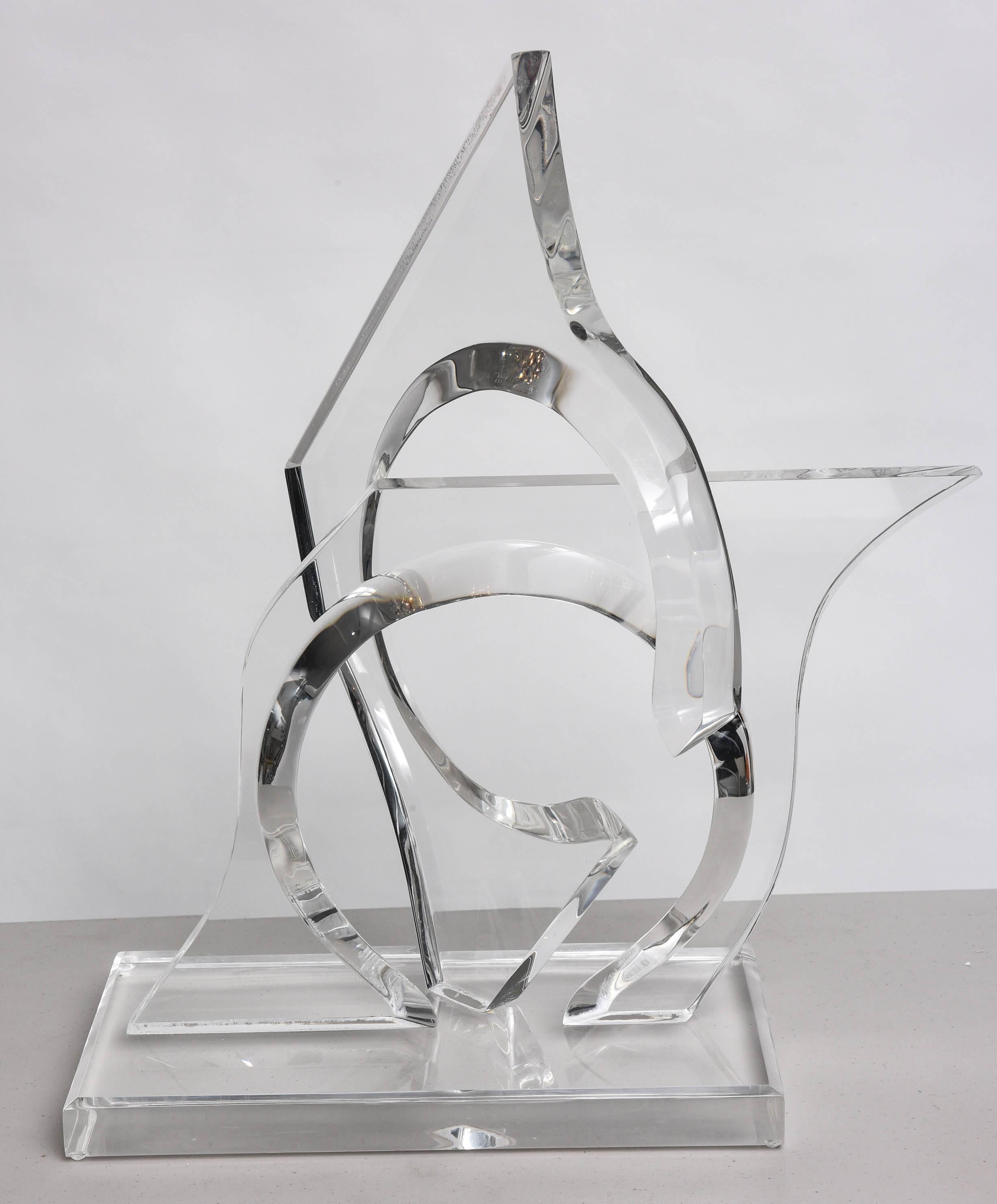 This amazing lucite sculpture was created by the iconic firm of Hivo Van Teal in the 1970s.  The free-form interlocking prism-like pieces have a great sense of movement and play as the light passes through them.

The piece is signed on the base