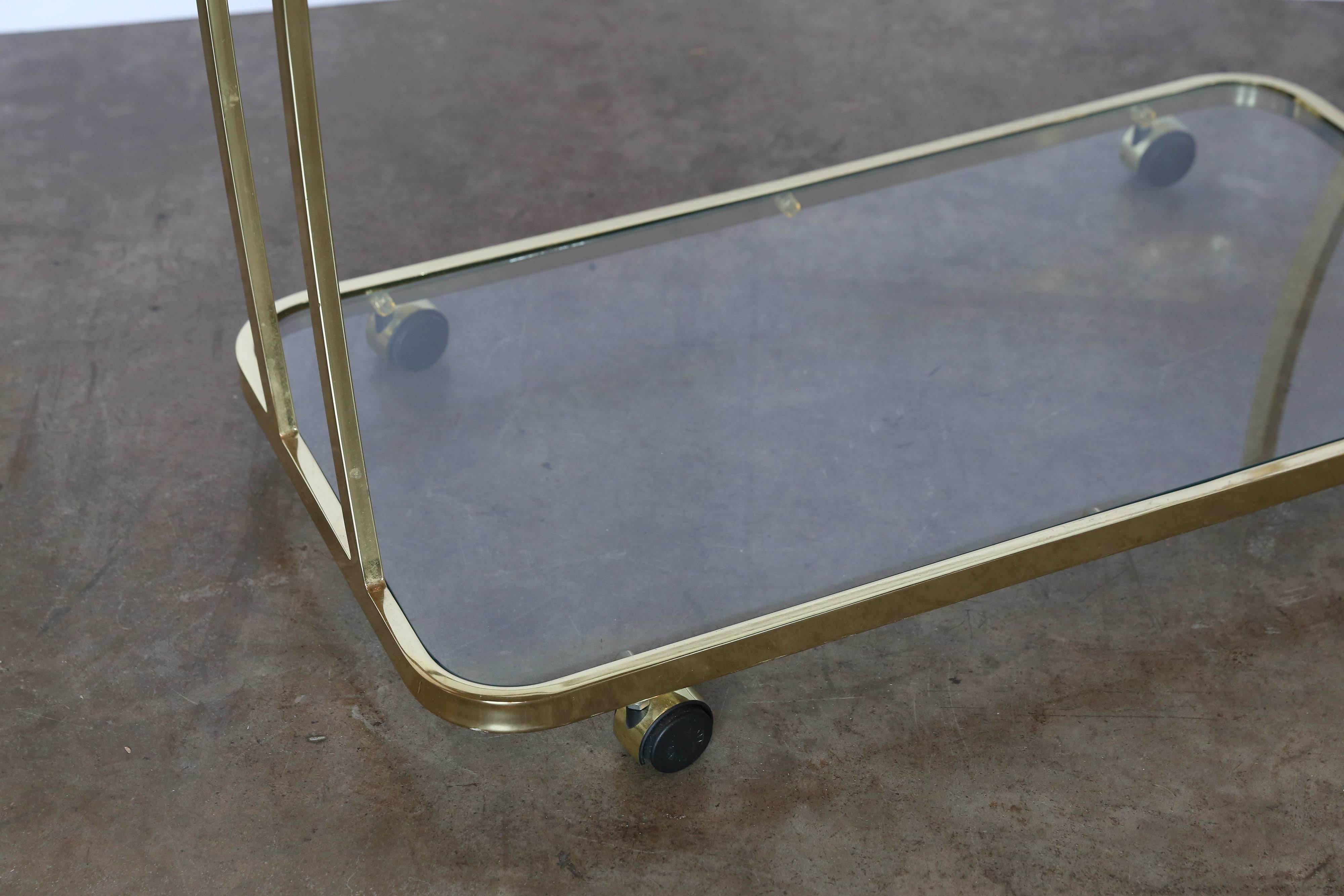 Offered is an 80s high glam shiny brass and glass three tier bar / drinks / tea cart / server attributed to Design Institute America. Sure to make entertaining more fun and memorable.