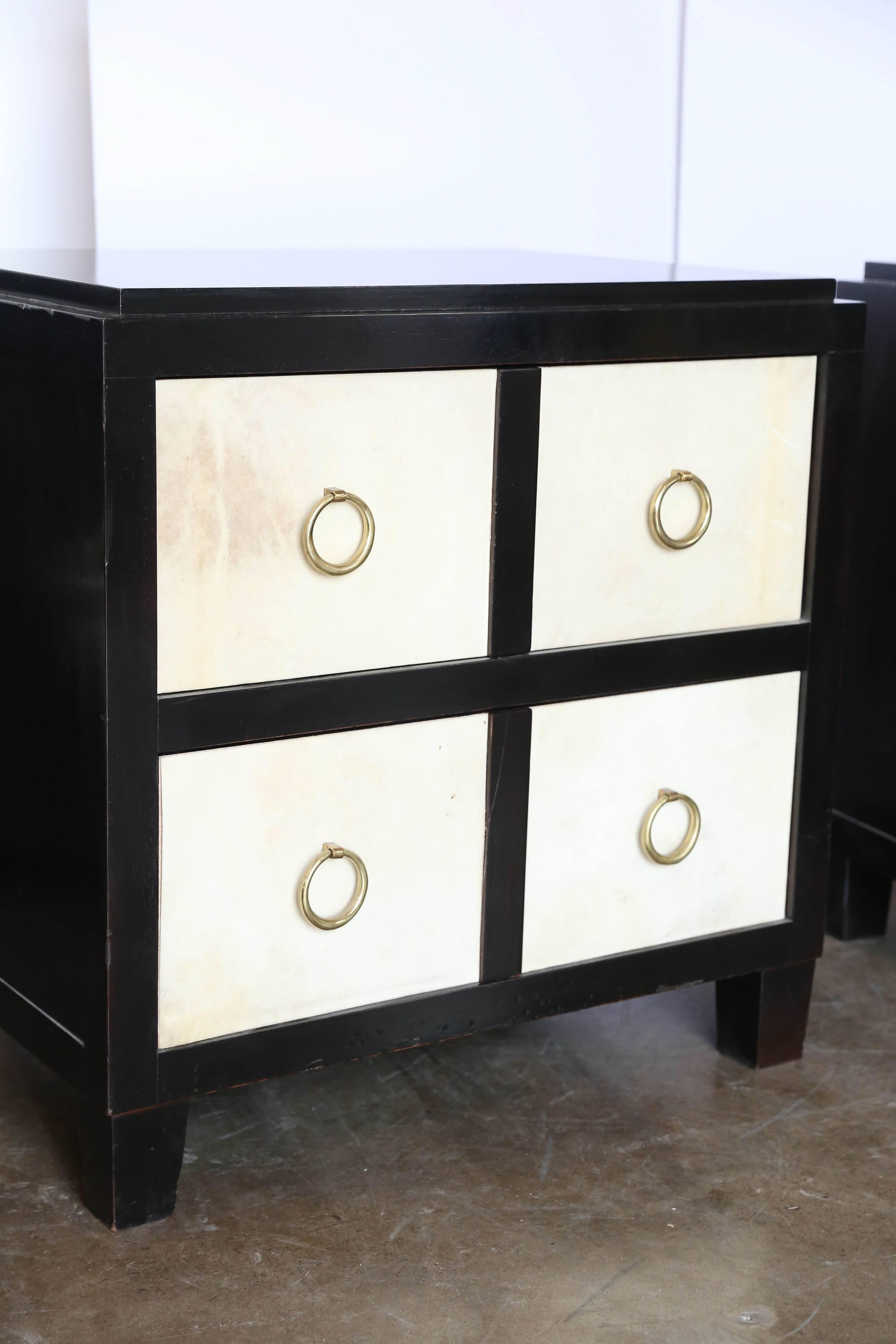 Offered is a pair of gorgeous "French Moderne" style bedside tables of ebonized wood, vellum and brass.  Recalling the work of Jean-Michel Frank, these two-drawer cabinets would add classic high glamour to any bedroom decor.