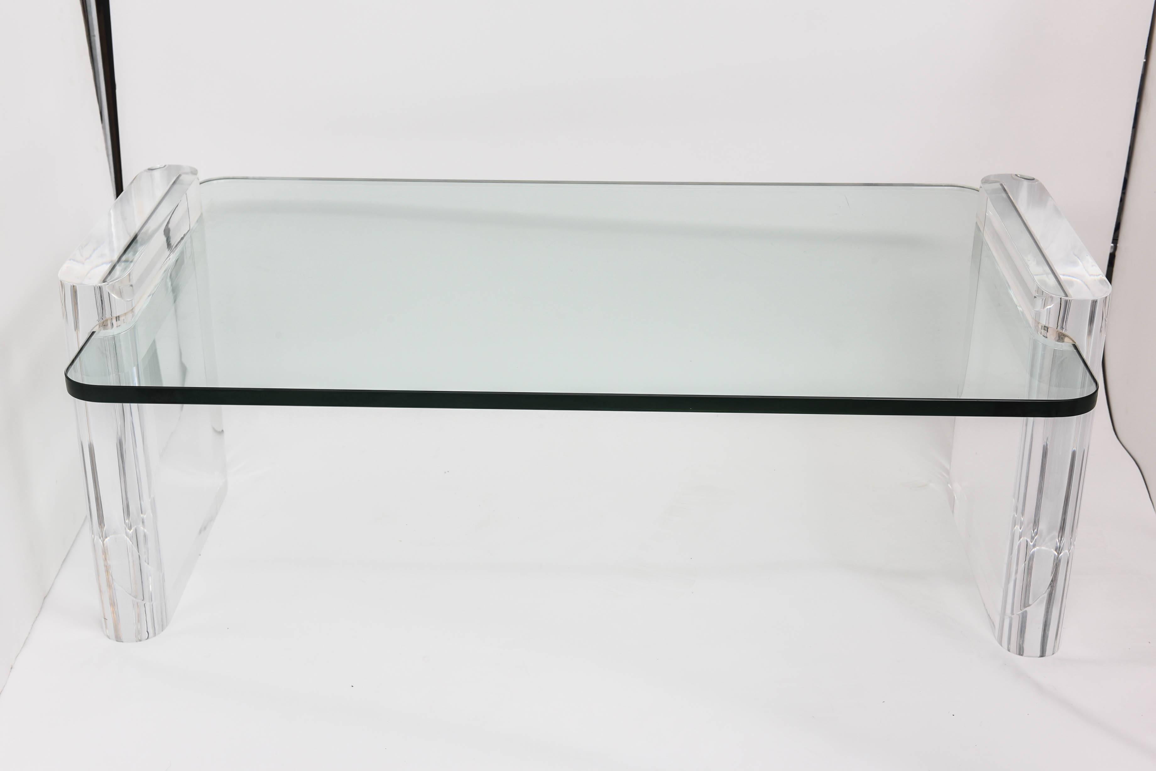 Stunning and elegant heavy Lucite and glass coffee table in the style of Karl Springer .