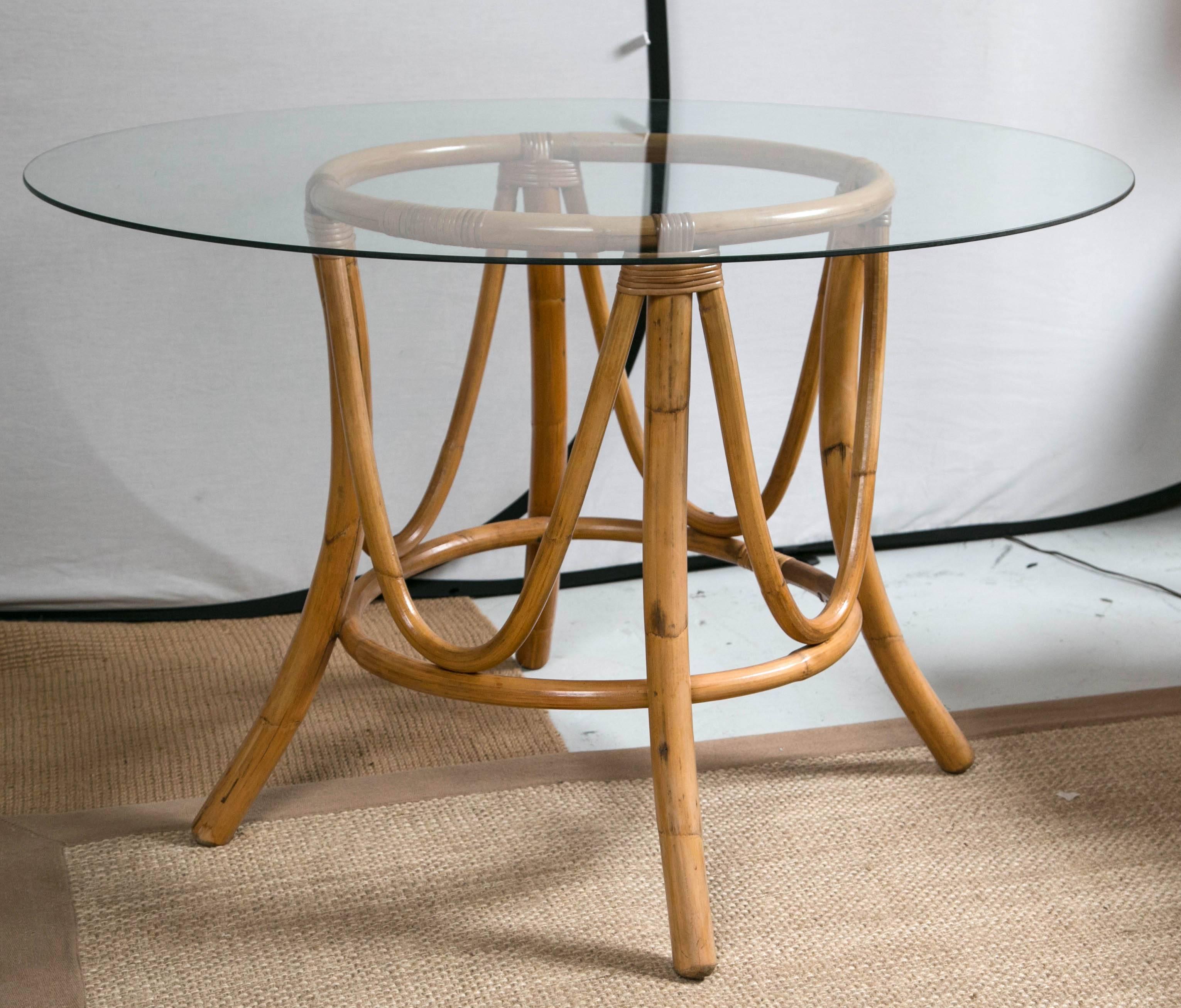 Glass-topped Rattan dining table with four swivel base chairs, original seat cushions and backs (removable) Round glass top is 44