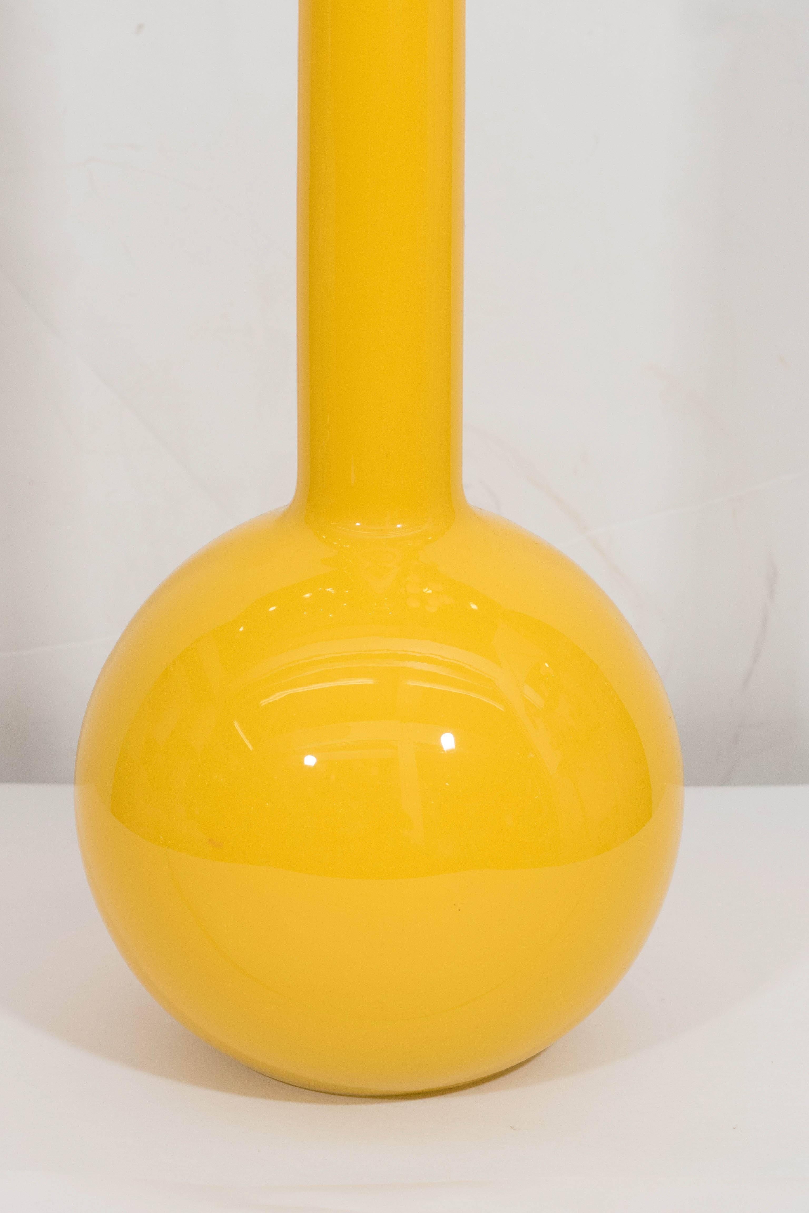 A vintage floor decanter in cased glass, produced circa 1960s by Empoli, with round green stopper, above a long-necked baluster form body in yellow. This piece is in excellent condition, consistent with age.

Item# 15-11-07.