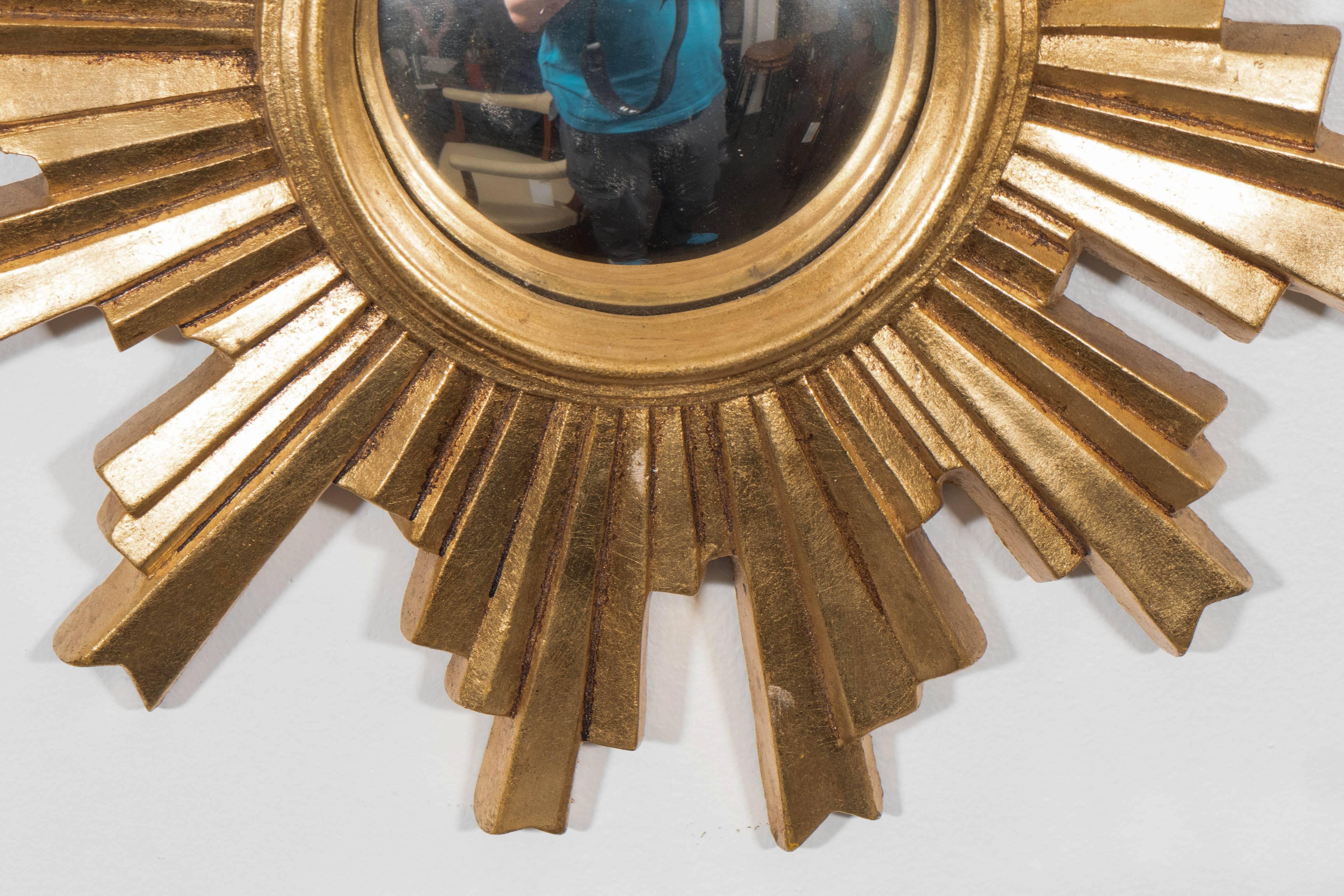 A vintage convex mirror, inset within a brilliantly gilded sunburst frame, produced in Germany, circa 1960s. Very good condition, with minimal wear to the gilt finish.