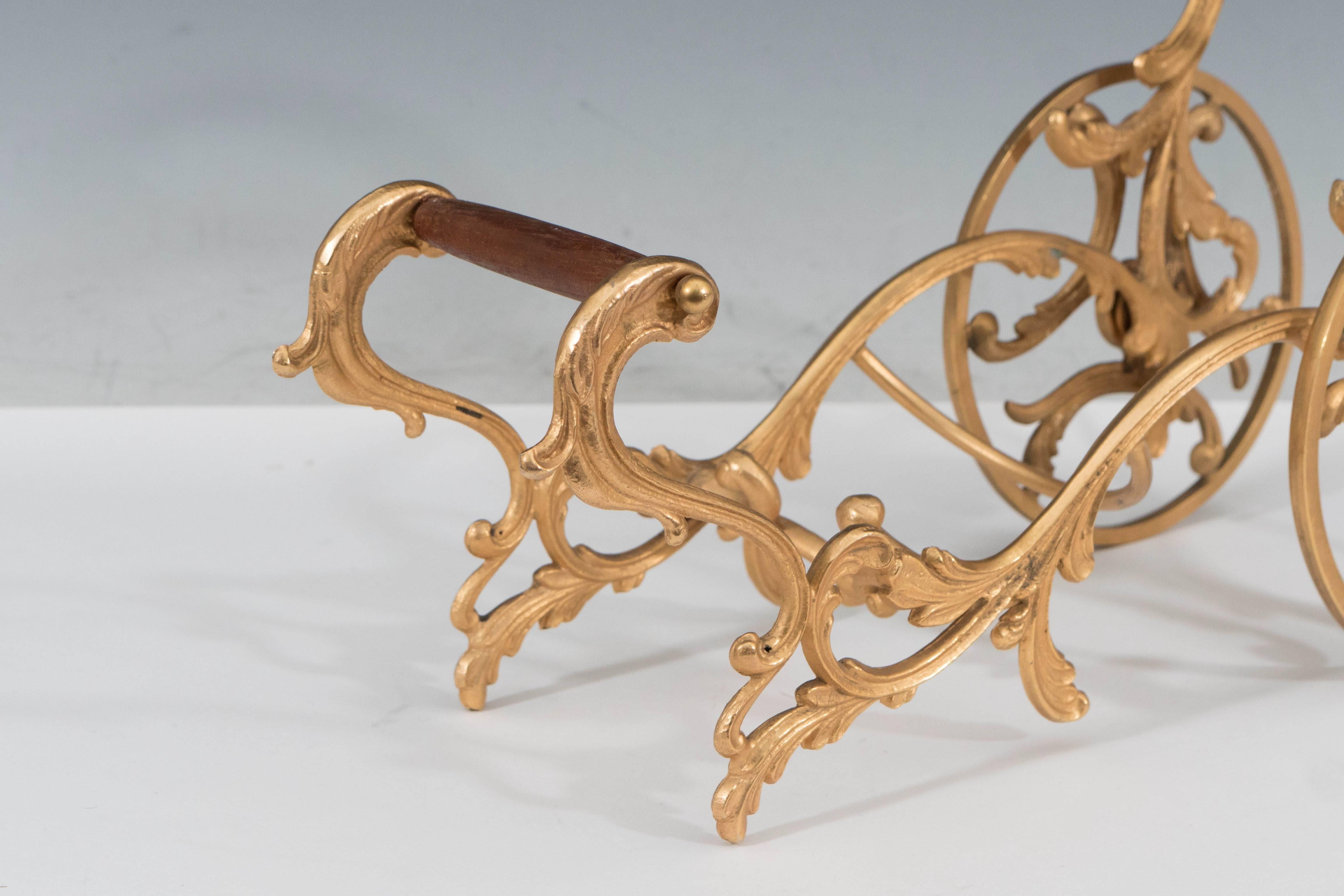 This vintage Italian wine holder from the 1950s, comes in the form of a whimsical chariot, on spoke wheels with wooden support, comprised of beautifully gilded, scrolling acanthus leaves. Overall very good condition, with minuscule wear to the