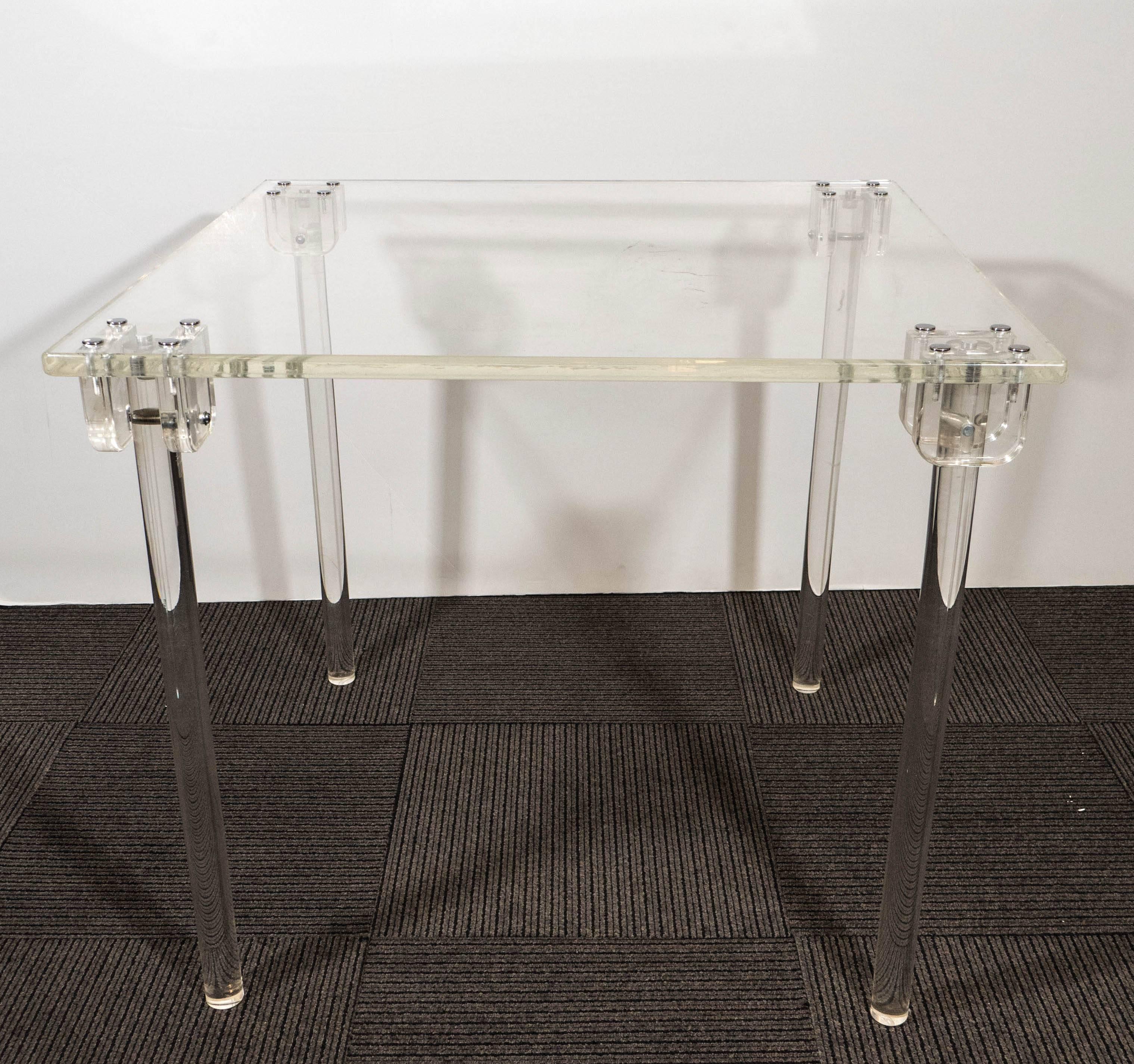 A vintage Charles Hollis Jones lucite folding card table, accompanied by a set of four highly modern 'Plia' folding chairs, by Italian designer Giancarlo Piretti for Castelli, each with backs and concave seats in lucite, against chrome frames. The