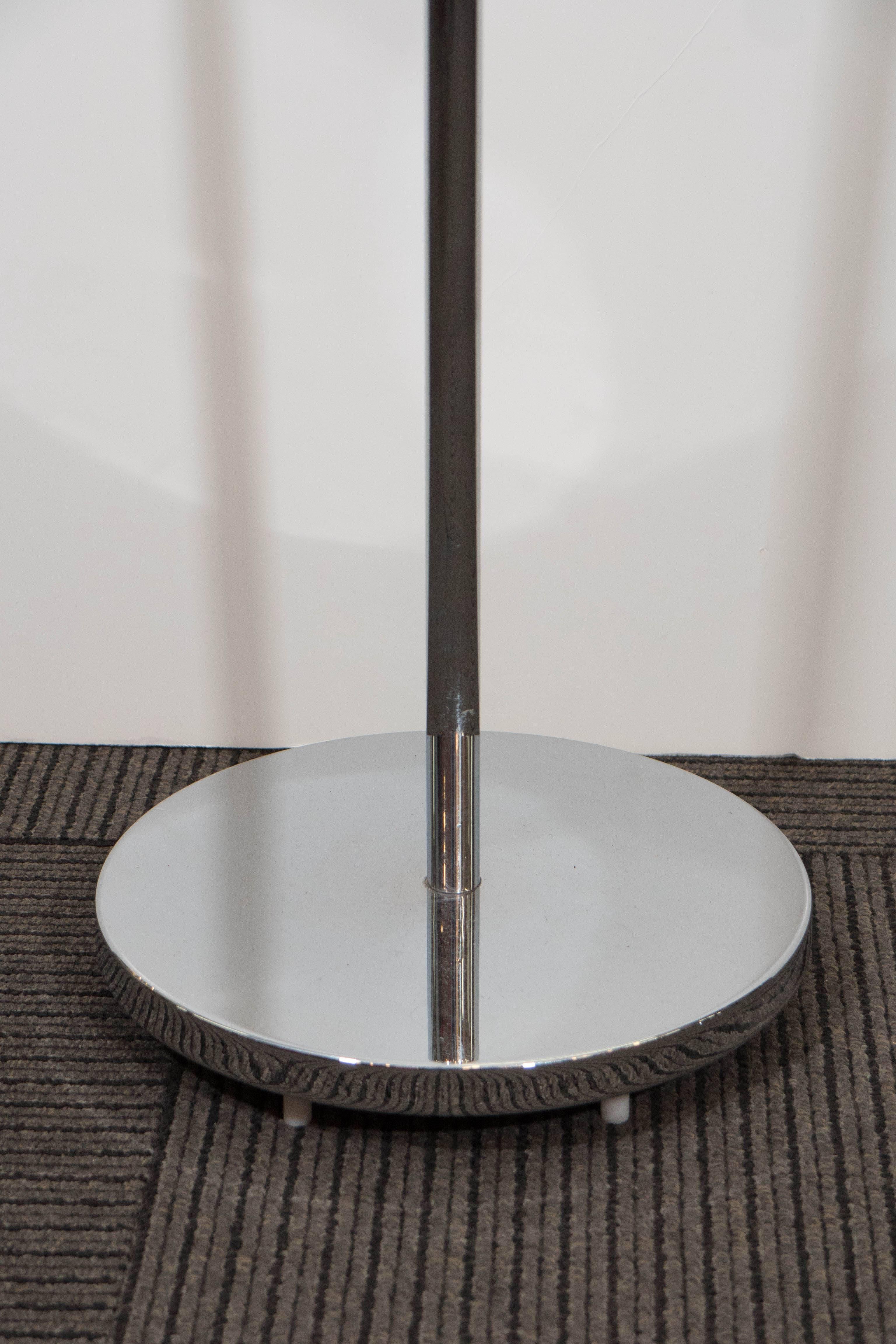 This reading floor lamp, produced circa 1970s by Casella, comes in polished chrome, the shade supported by an adjustable curved stem, on a circular base. Markings include Casella label, set beneath the base. Overall very good condition, with minimal