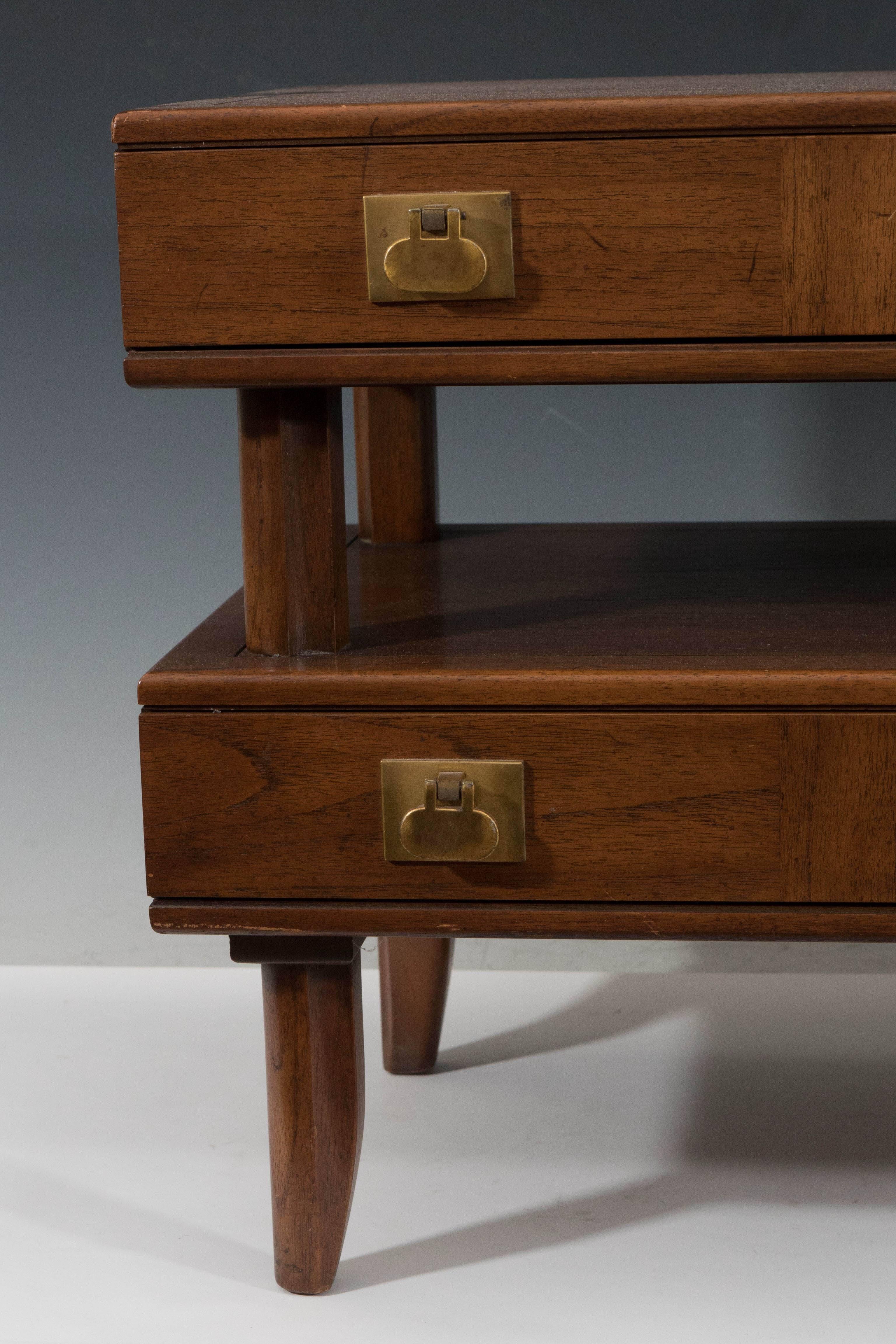 A vintage small chest of drawers in wood, produced by Mastercraft circa 1970s, the drawers separated into two tiers, with brass pulls, raised on tapered legs. Markings include the manufacturers label [Mastercraft Furniture Co./Grand Rapids, Mich.],