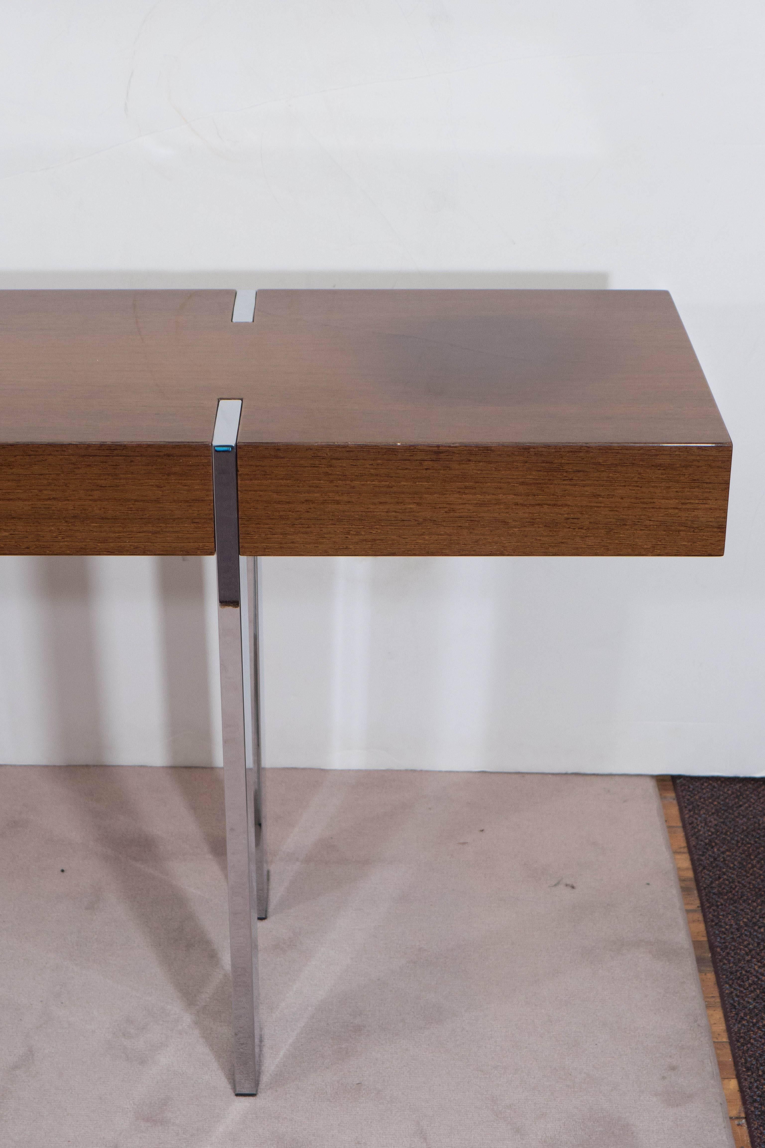 A lengthy console table, with high gloss lacquered wood top, mounted on chrome flat legs. Very good condition, wear consistent with age and use.

10427
