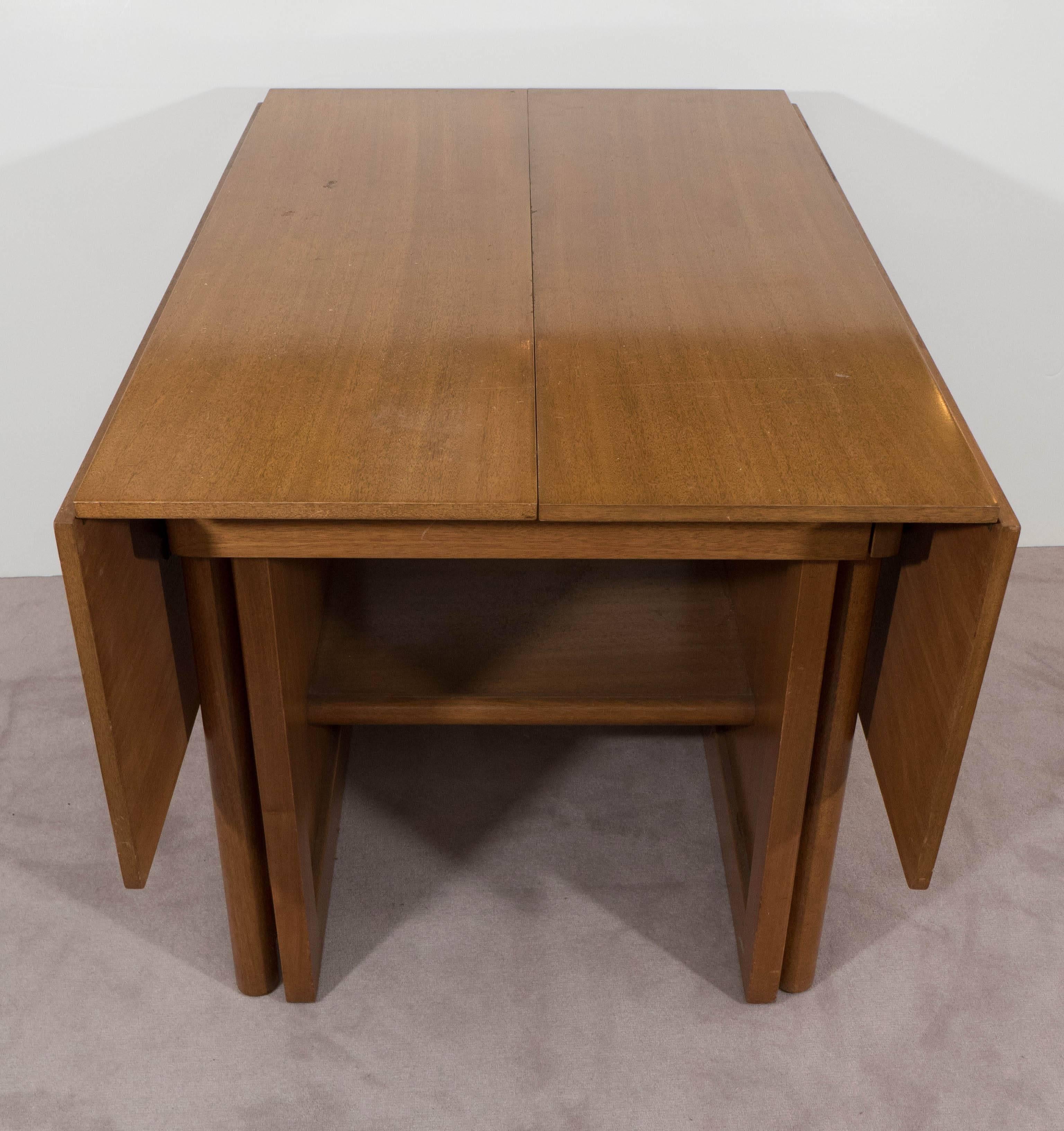 A vintage extension dining table, produced by Dunbar, circa 1940s and designed by Edward Wormley (Model 4576), which includes drop-leaf sides and five leaves. At full length, this piece extends 126". This piece is in overall very good