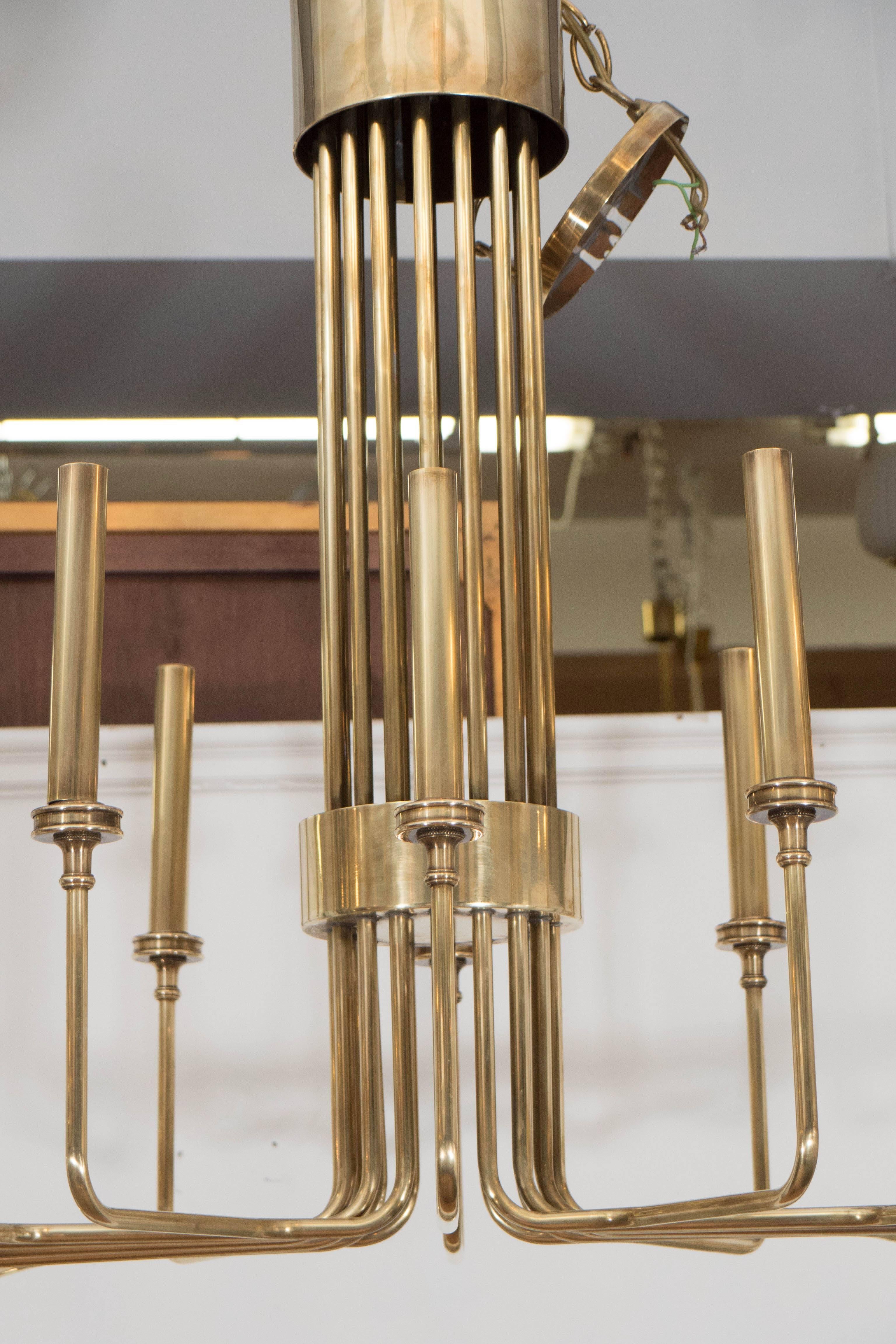 A vintage modernistic chandelier by Hart Associates, designed in the style of Tommi Parzinger, produced circa 1960s, entirely in brass, each of the sixteen lights supported by a curved beam, grouped in the center. This light fixture is in overall