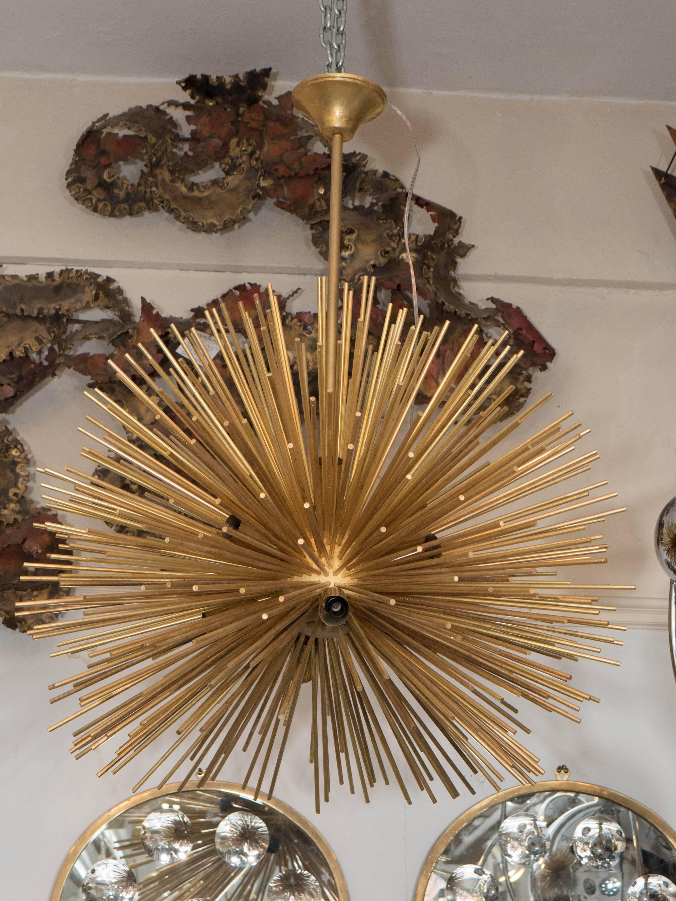 An Italian Sputnik chandelier, produced within the late 20th century period, with sockets projecting from the central nucleus, surrounded by an array of brass beams, entirely suspended from a pole support and tapered canopy. Very good condition,