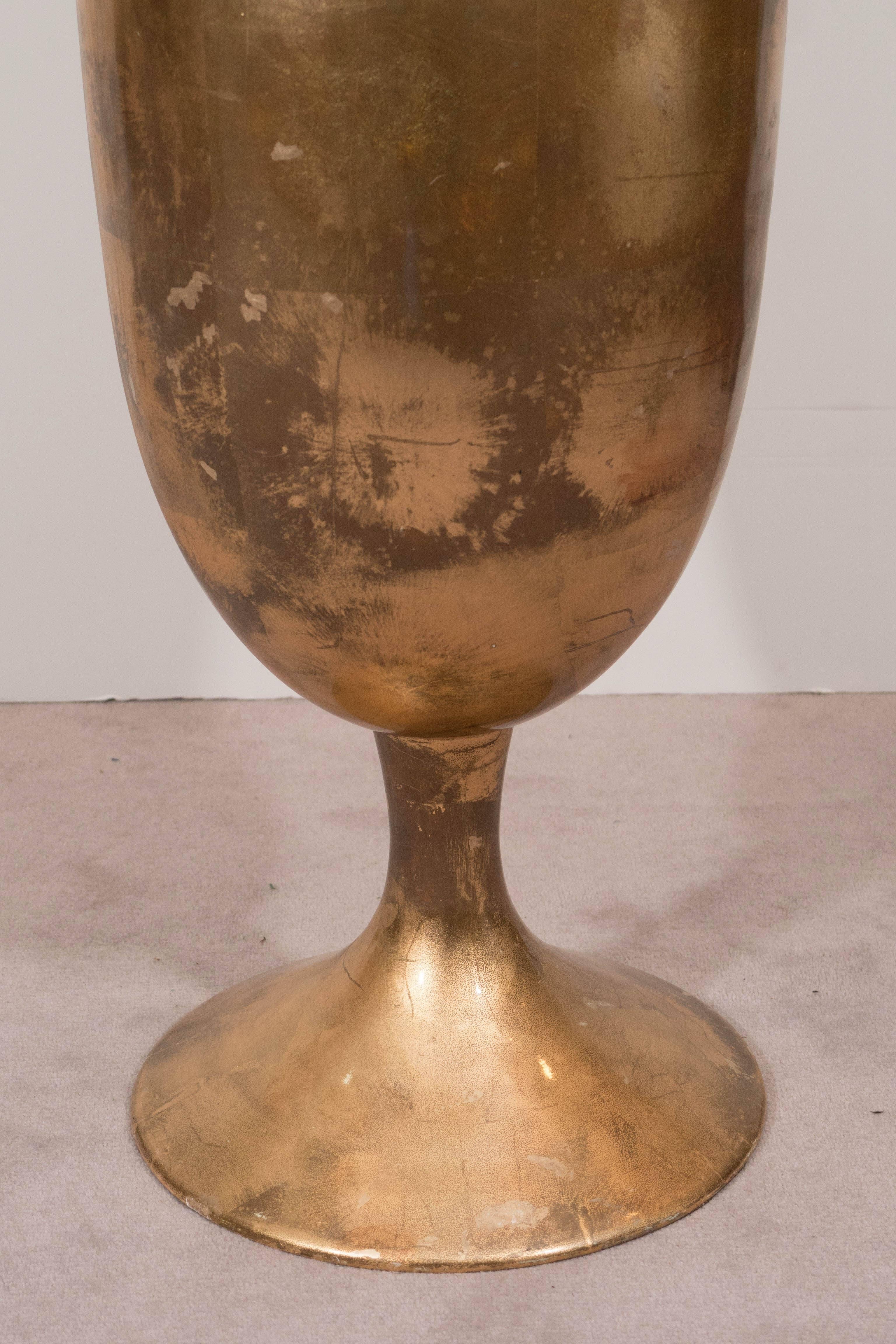 A very unique, large-scale ice bucket, produced circa 1970s, with rounded body and baluster point, raised on a single foot, in lacquered gold-leaf finish against wood; interior lined with white plastic. This piece is in very good condition, with