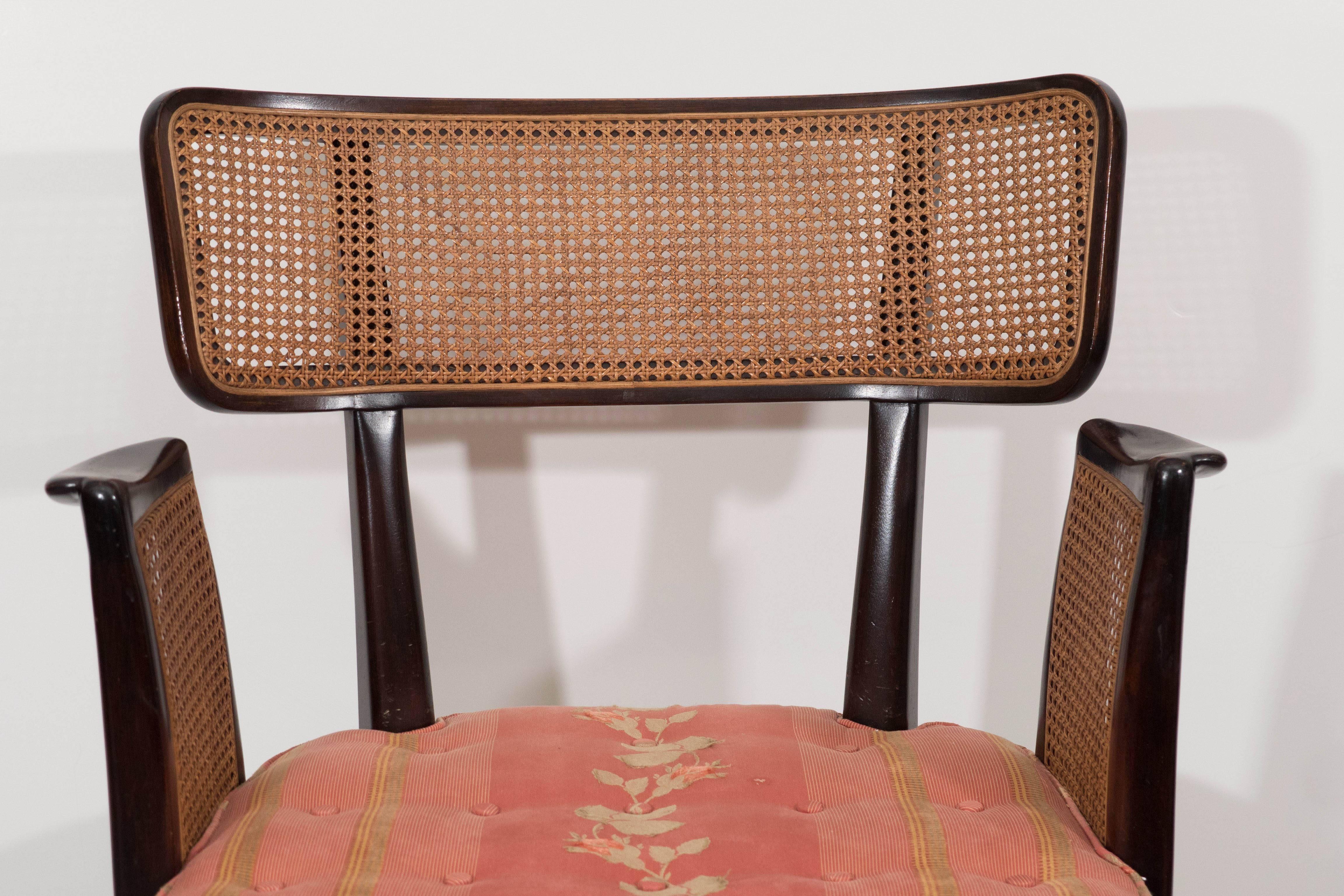 A vintage set of six dining room side and armchairs, designed by Edward Wormley for Dunbar circa 1940s, in dark wood, with cane backs and tufted cushion seats on gently curved Klismos legs; the two armchairs include raised arms with caning. Overall