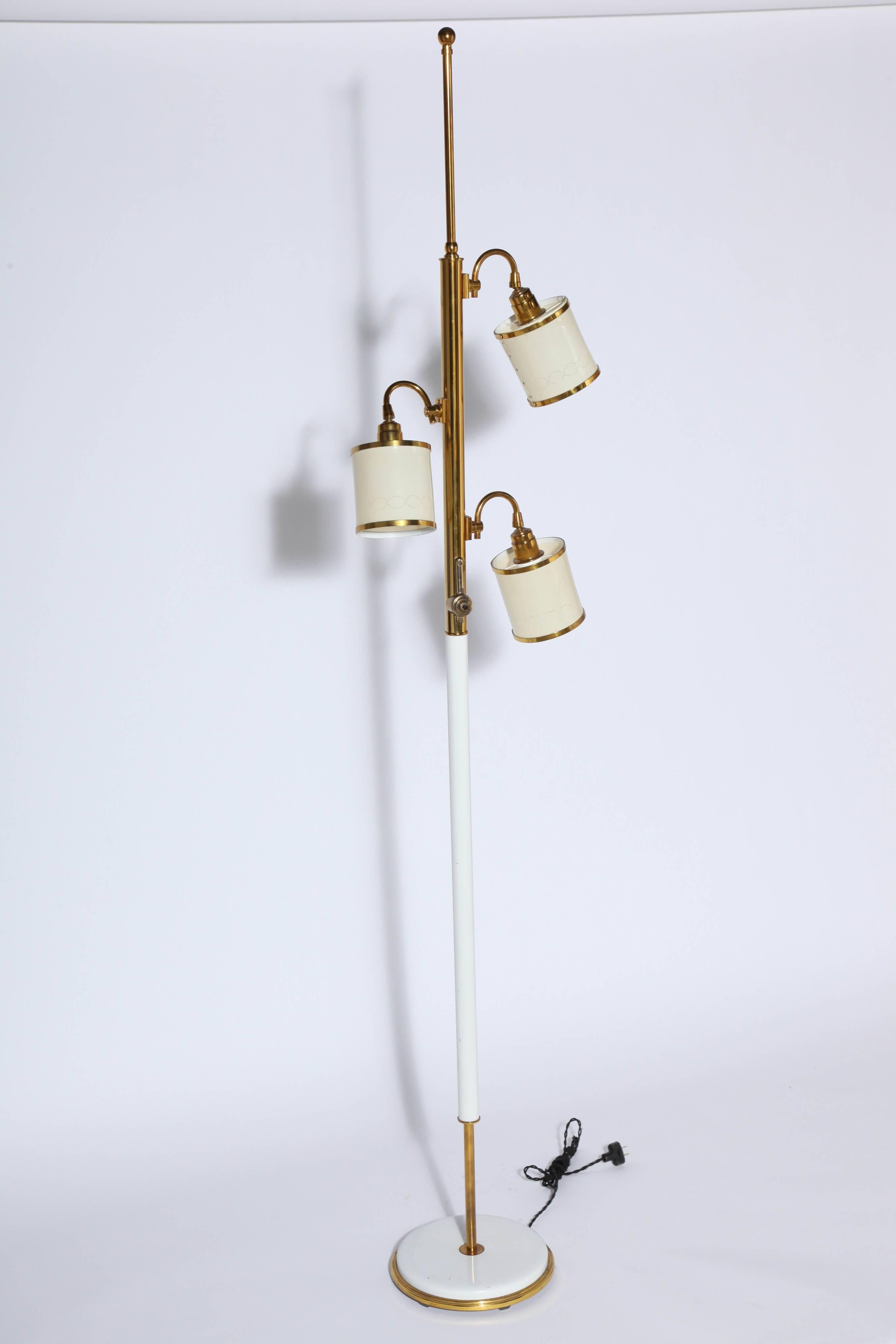 Stiffel Adjustable Reading Floor Lamp with three perforated cream shades, in the manner of Tommi Parzinger. Featuring an upper brass tubular stem, white enameled metal lower, 3 adjustable perforated cream plastic swing barrel shades (4.5 D x 4.75 H)