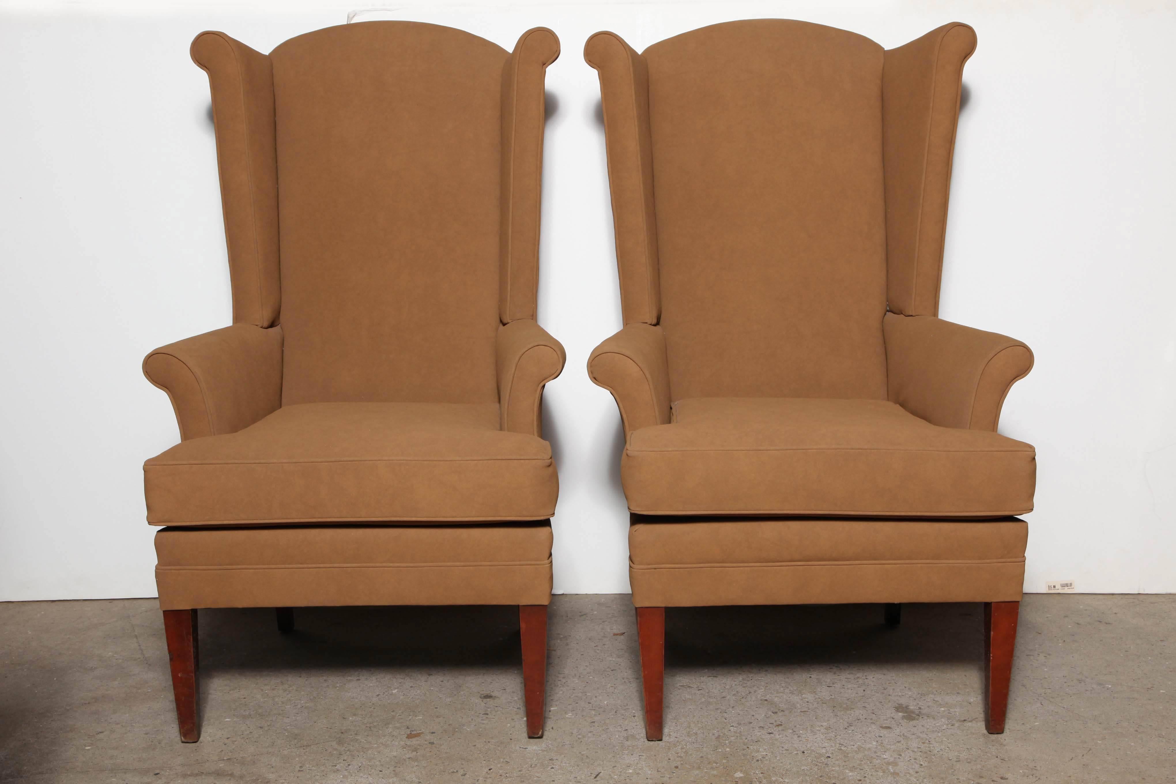 2 classic, MCM comfortable and solidly constructed High Back Wing Back Chairs. Upholstered in a clean and neutral, creamy Coffee or Camel ultra-suede, supported by four Walnut legs.  Great as Host and Hostess Dining Room 
Arm Chairs, Den Chairs,