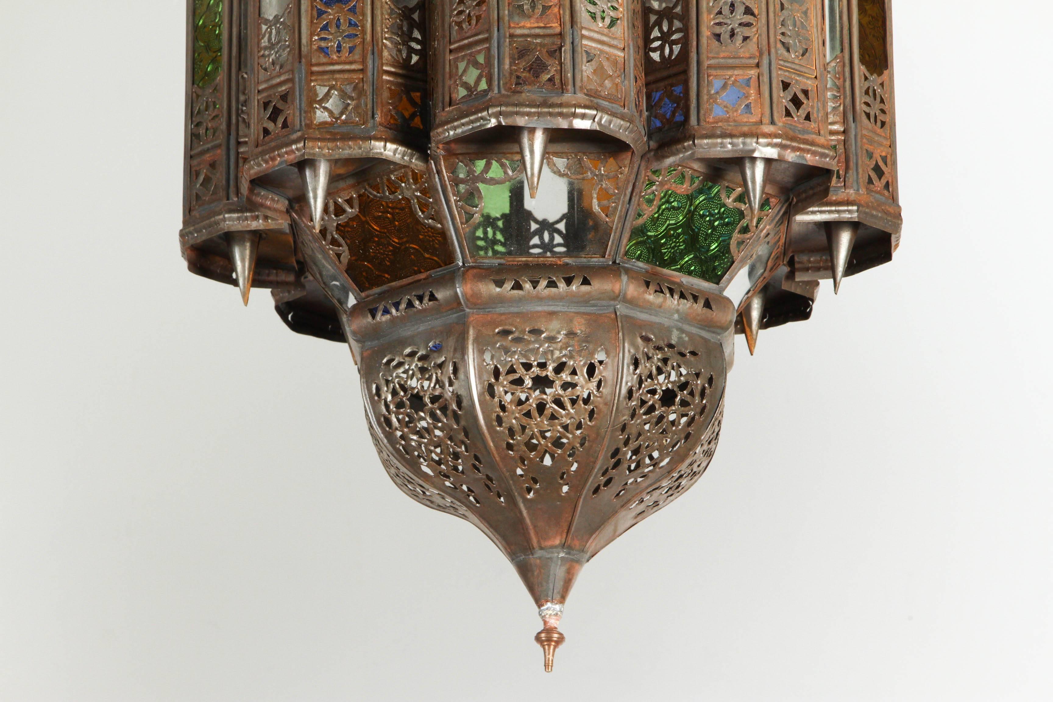 Large Moroccan Mamounia style pendant lantern.
Multicolor glass, blue, green, amber, lavender and clear, multifaceted and intricate filigree Moorish work on metal, bronze patina rust finish.
Brass final.
Handcrafted in Morocco by skilled