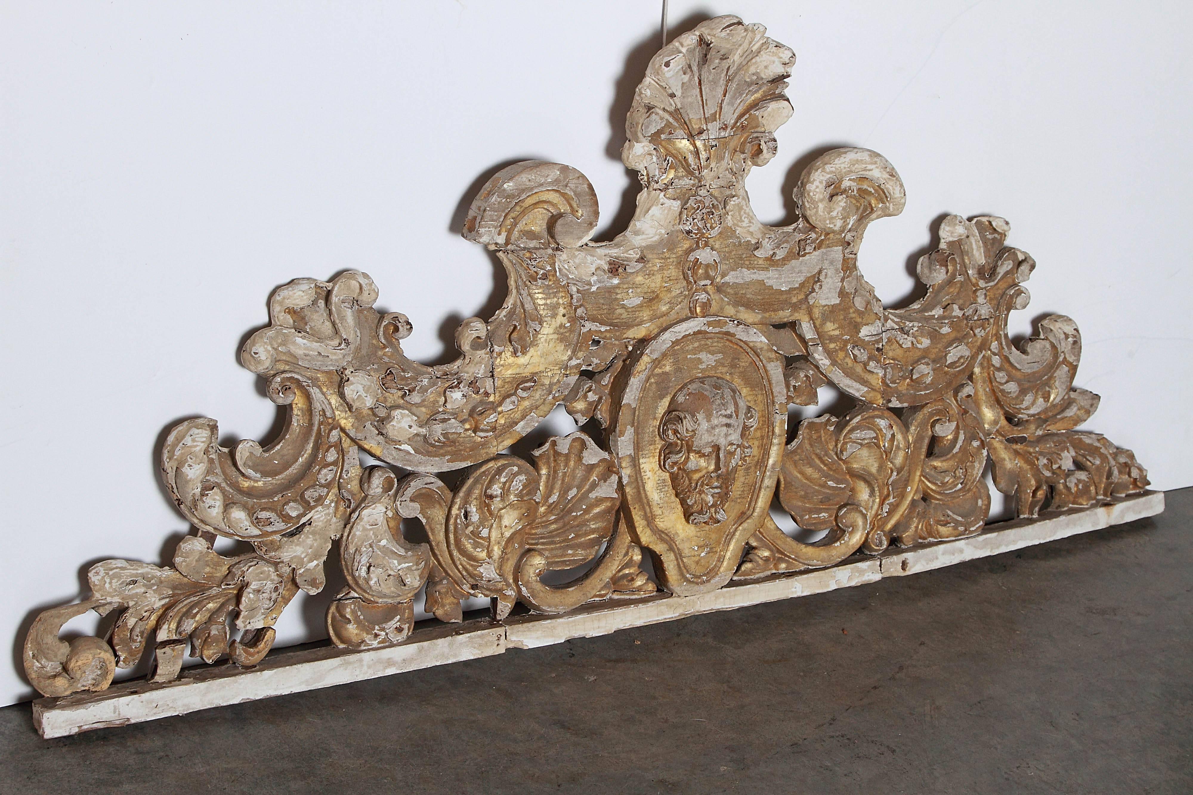 This extraordinary hand carved overdoor from Sicily dates to the 1700’s.  In the Baroque style, the carvings have flourishes of rocaille, gadrooned leaves, stylized shells, c-scrolls, feathered acanthus leaves, and a central oval with a mascaron. 