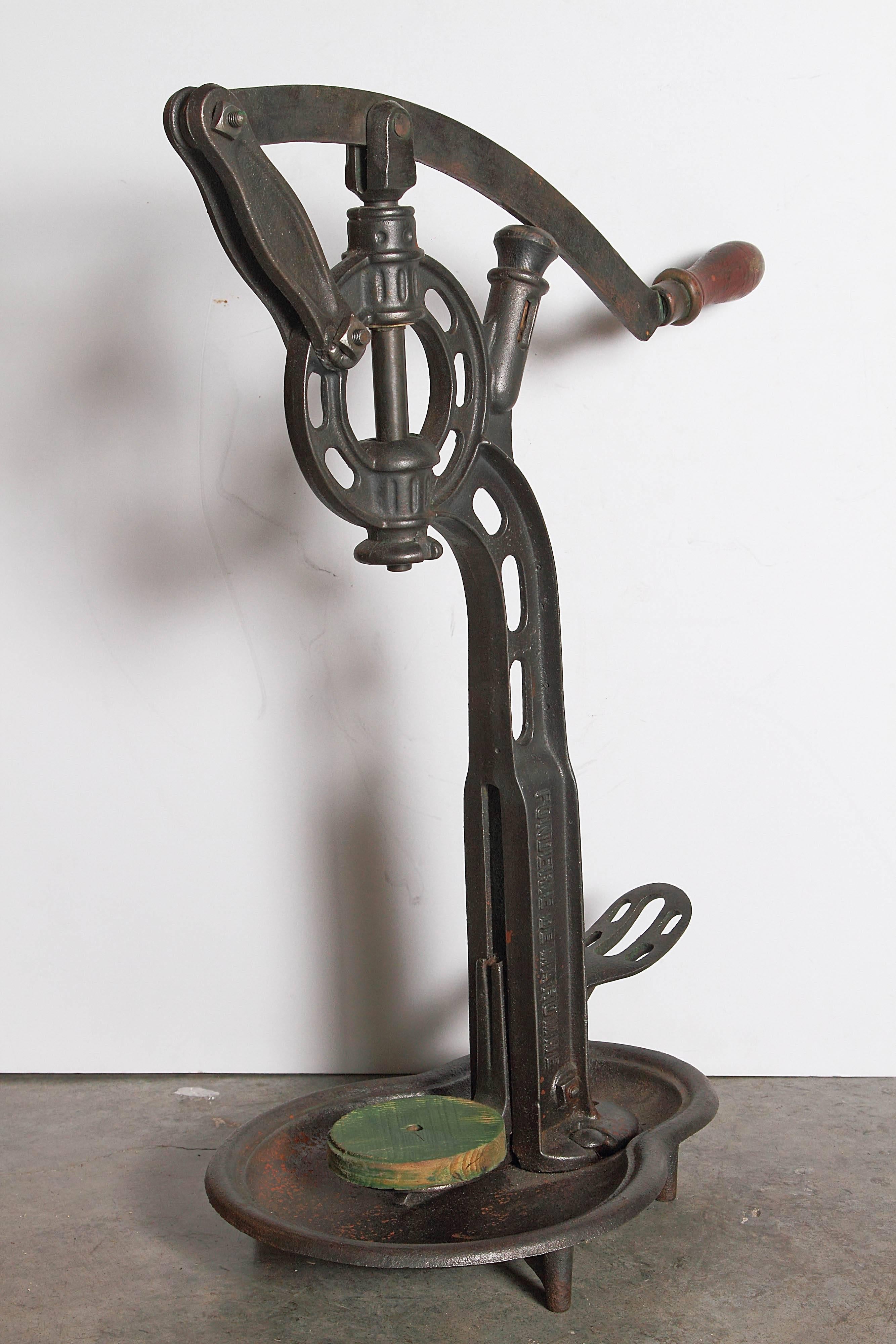 This antique French cast iron wine corker has foundry marks of Fonderie de Maromme on its horizontal shaft and its tray.  Its iron arm has a shaped wooden handle for corking the wine bottle. 
 
These are often used as a wonderful accessory in wine
