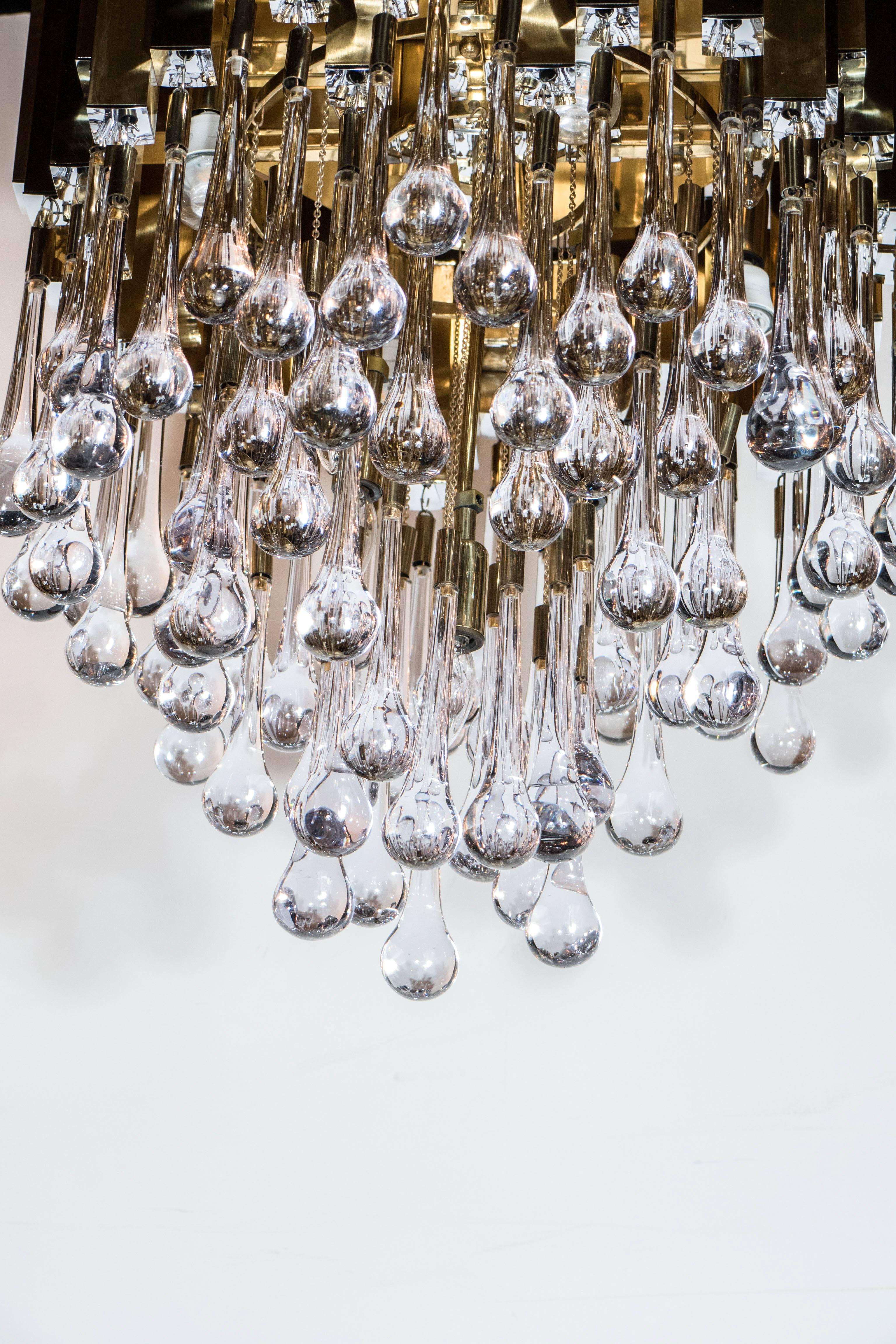A stunning Mid-Century Modernist Chandelier consisting of a rectangular tubed frame of polished brass above a series of tiers of crystal 