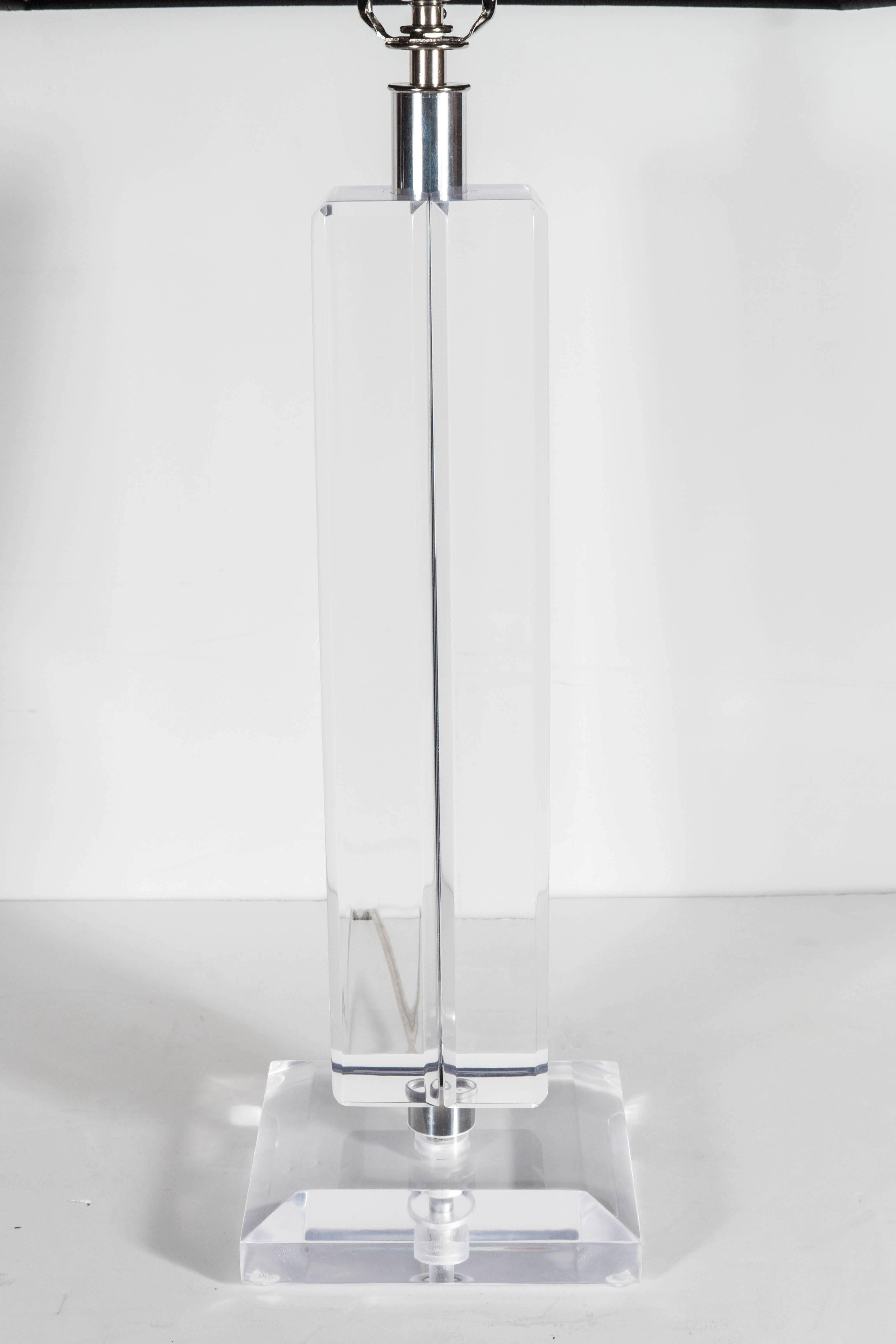 Ultra-chic pair of Mid-Century Modernist lamps in Lucite and chrome in the manner of Karl Springer. Thick, beveled bases and a chrome ring support two solid Lucite symmetrical stems. A very elegant pair for any bedside or occasional tables. The