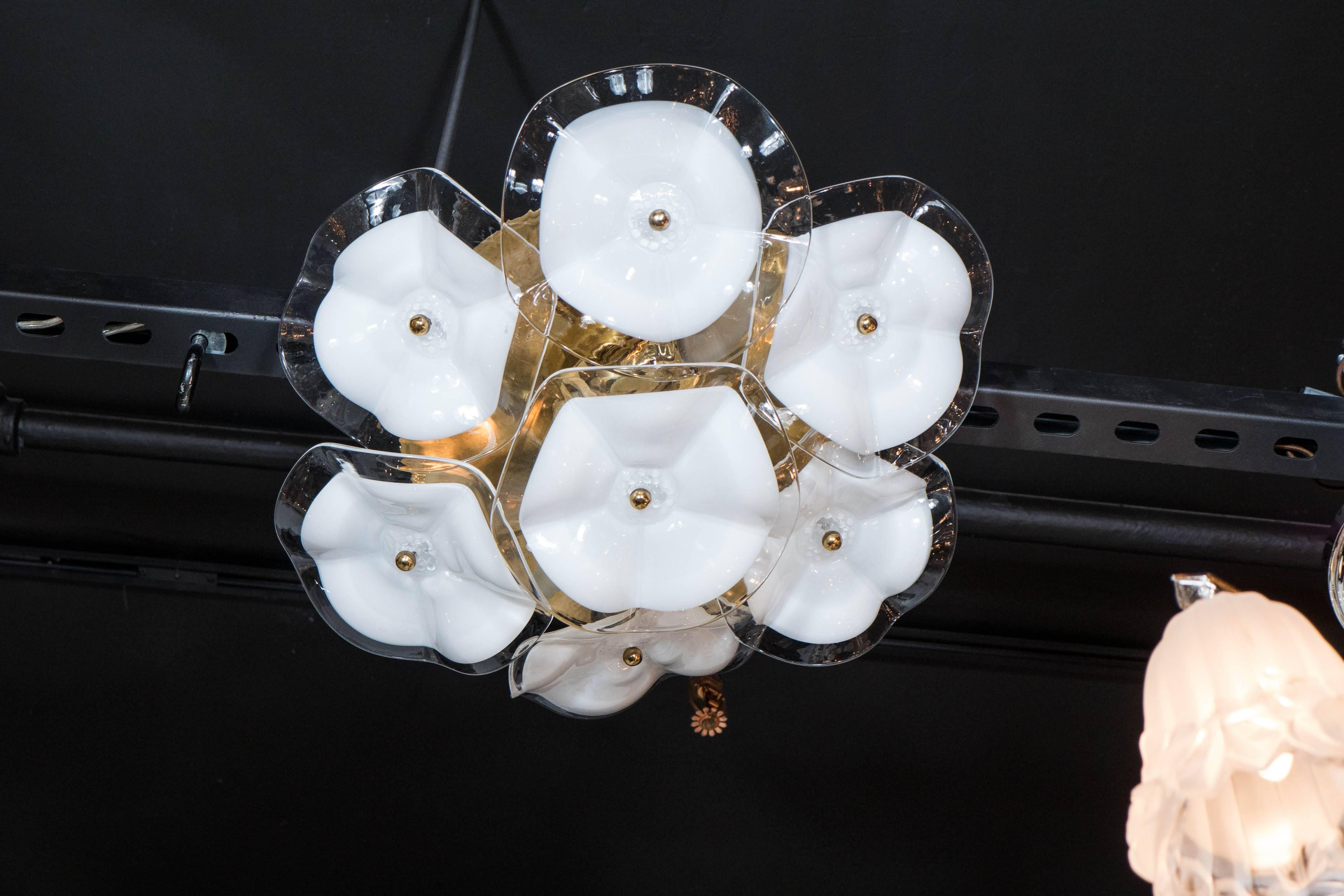 An exquisite Mazzega flush mount chandelier consisting of a polished brass cap supporting seven two-toned glass flowers held in place by brass pearl fittings. Each piece is handblown. The clear and white glass pieces appear to float as they are