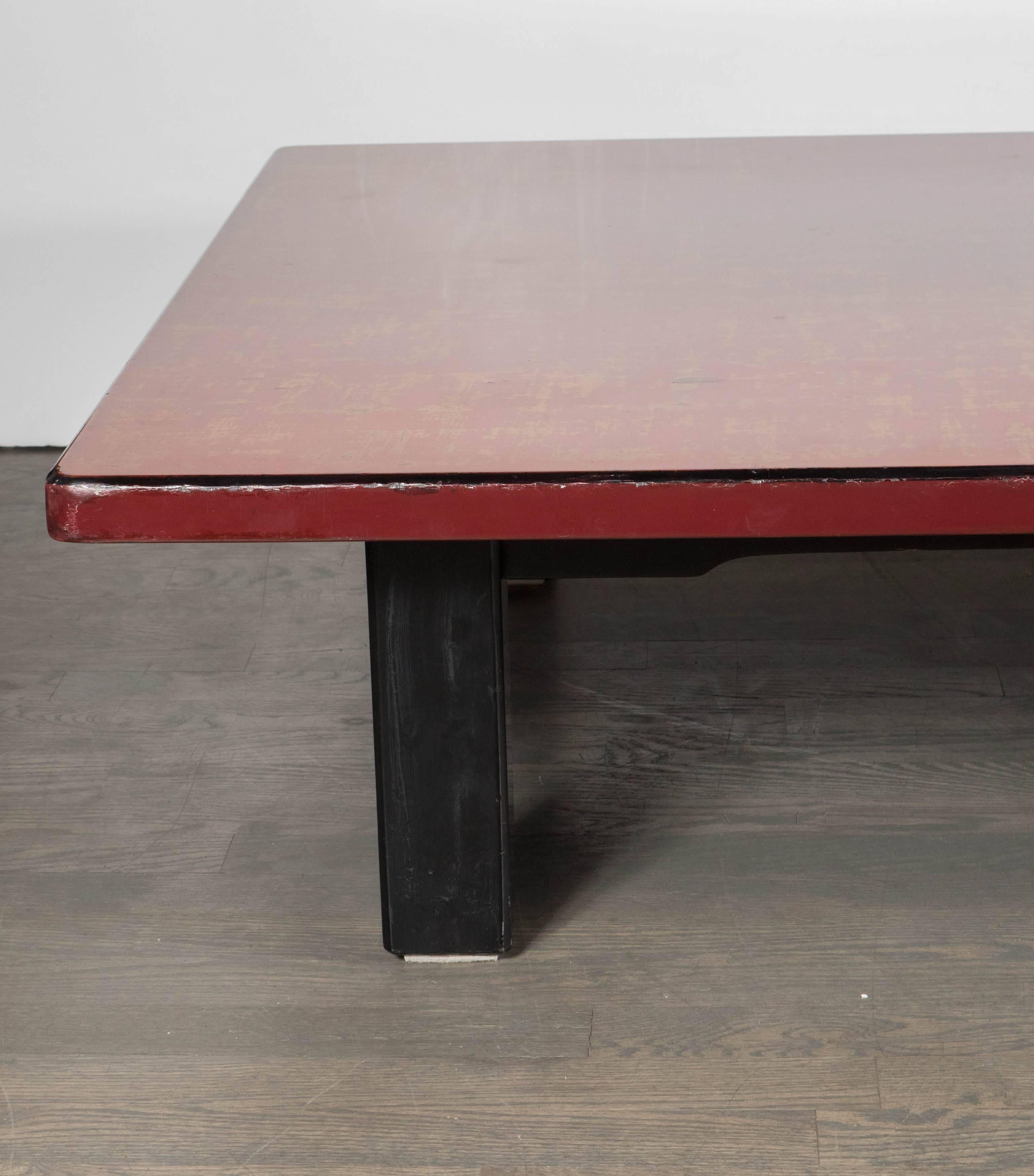 Mid-Century Modern an elegant Chinese red lacquered low coffee table on ebonized table legs, the impressive red lacquered hand rubbed rectangular tabletop rests on four powerful square shaped short ebonized wood table legs finished in sophisticated